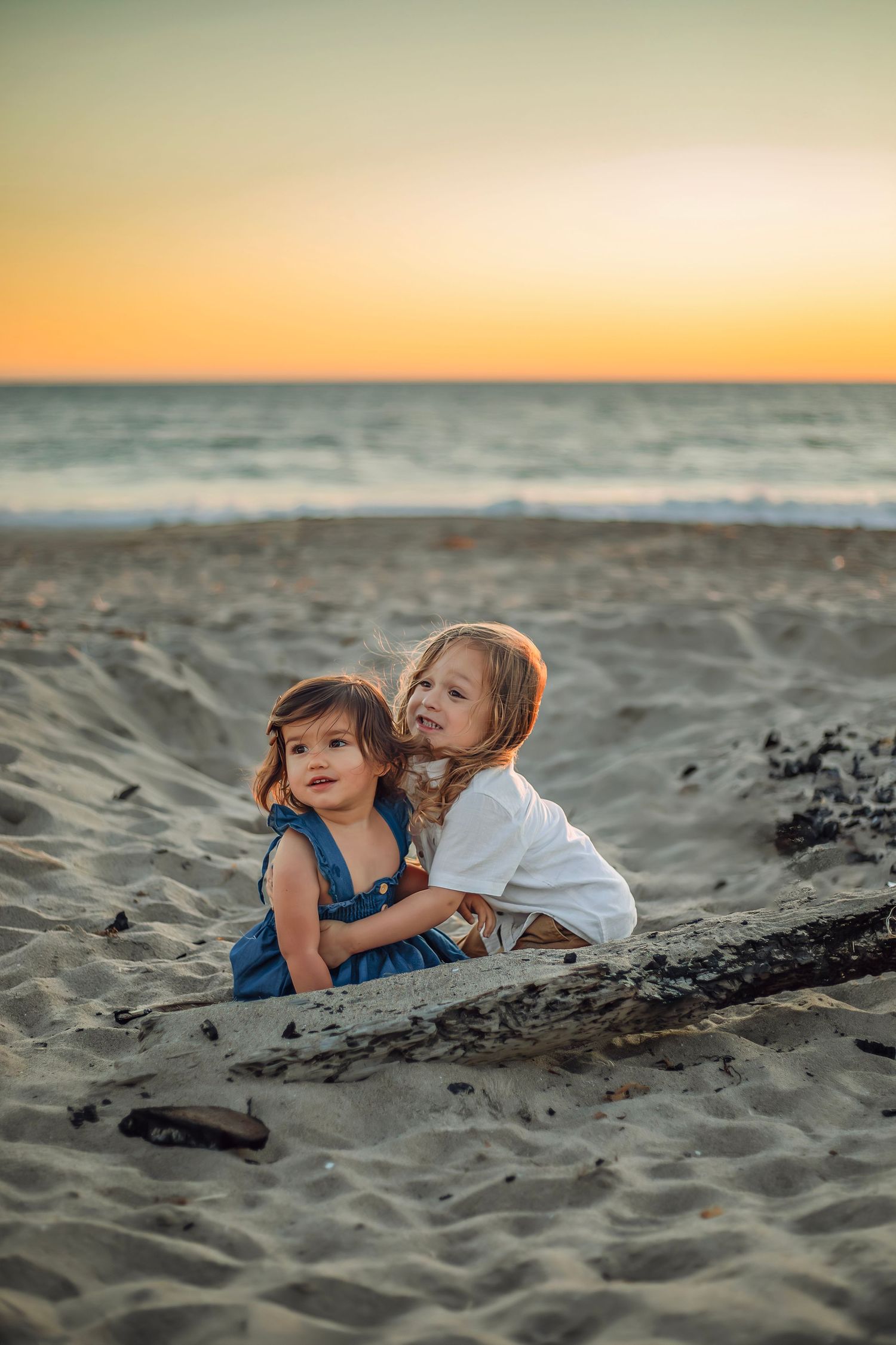 Children playing at the beach in Santa Cruz during golden hour, captured in natural light with candid, joyful moments and coastal scenery.