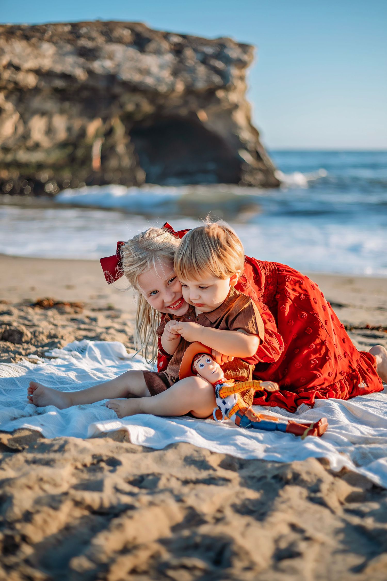 Siblings hugging at a beach in Santa Cruz, CA