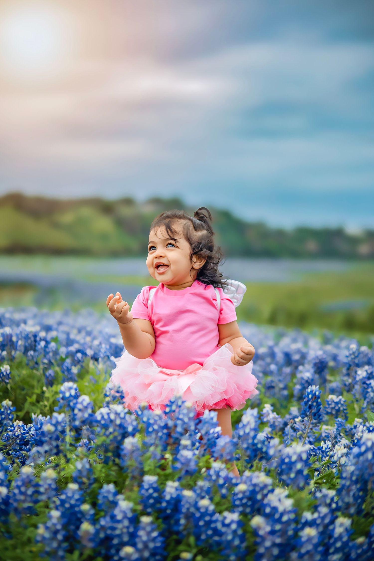 Little girl in a wildflower field, captured in natural light with candid, joyful moments surrounded by flowers and a serene outdoor setting.