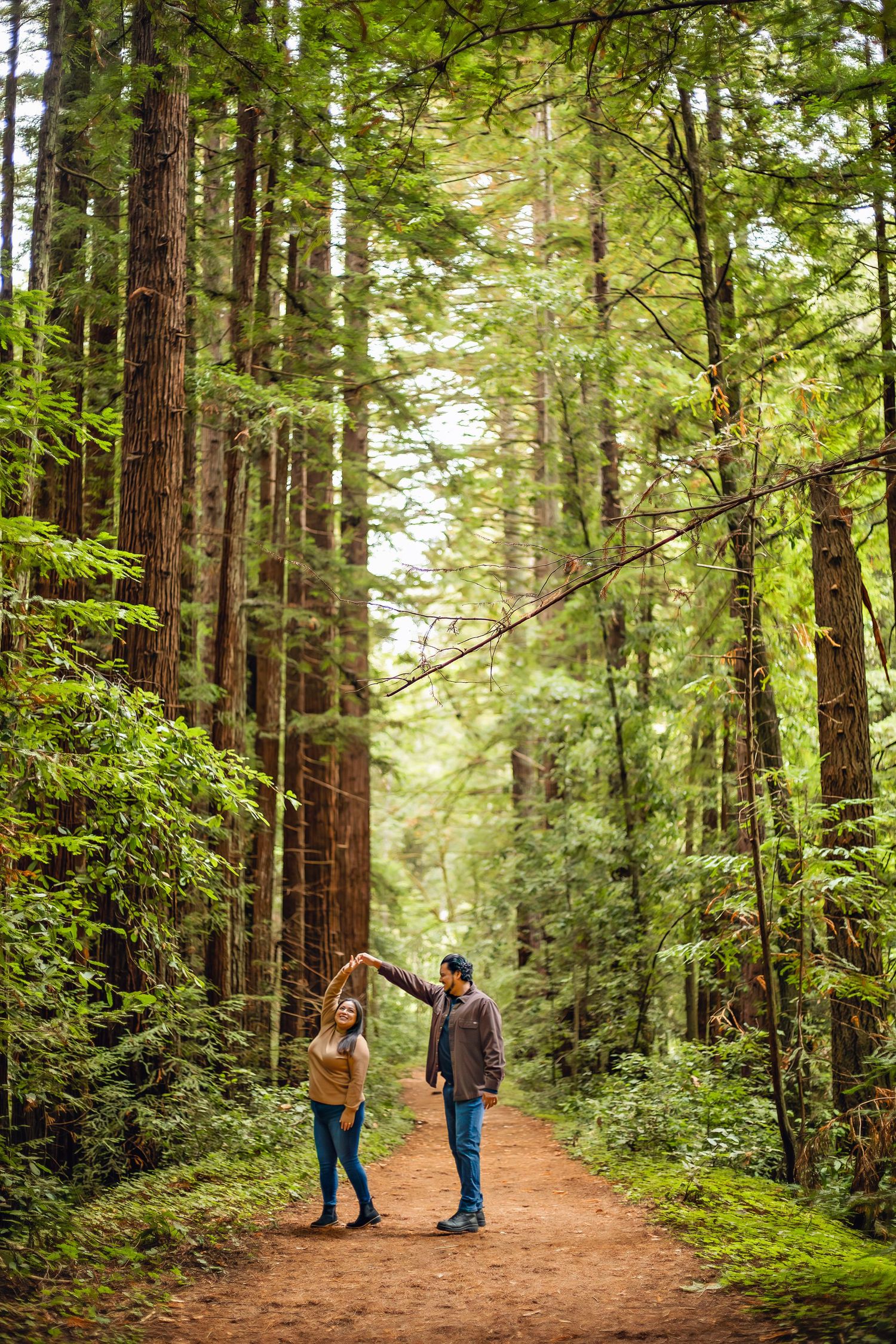 A couple in the Santa Cruz redwoods, captured in natural light with candid moments among towering trees and a peaceful forest session.