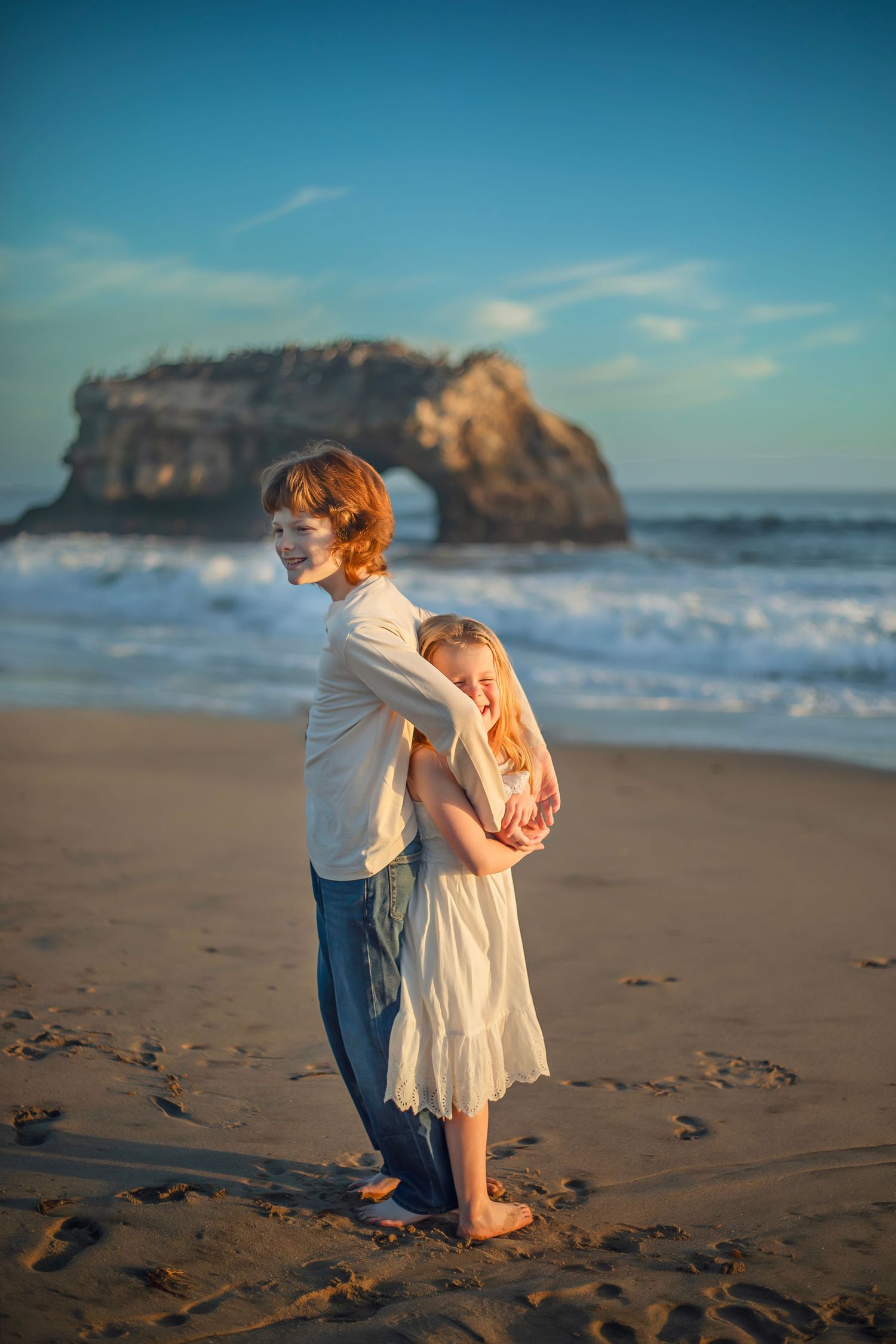 Children playing at the beach in Santa Cruz during golden hour, captured in natural light with candid, joyful moments and coastal scenery.