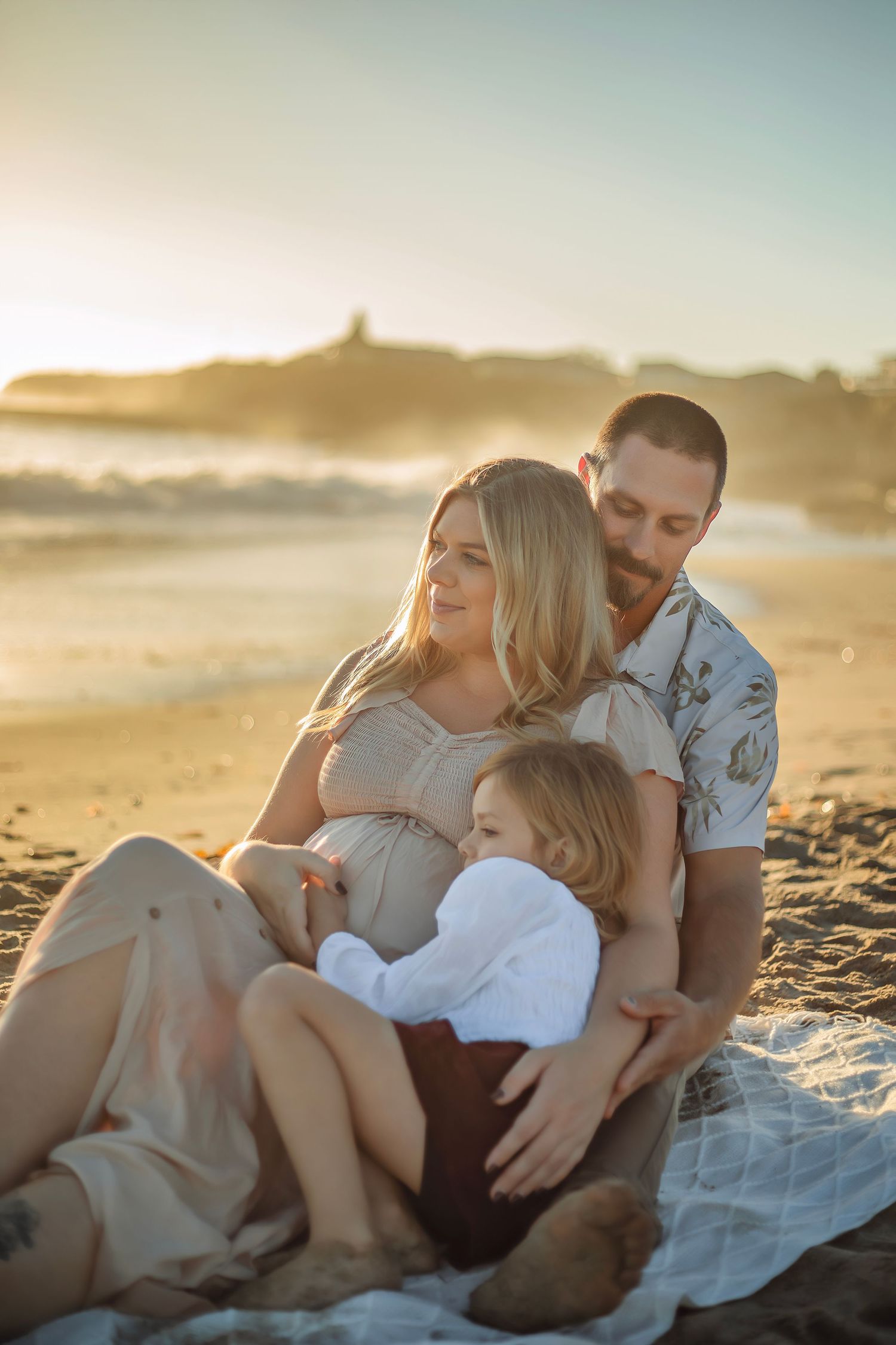Family maternity photo session at a Santa Cruz beach, candid moments, ocean views, and a warm, relaxed coastal atmosphere.