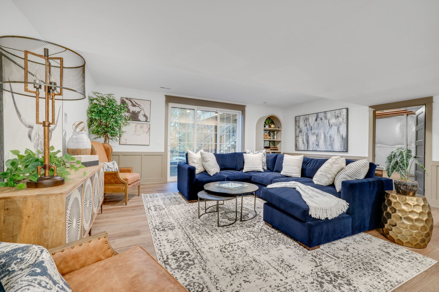 Cozy living room with sectional sofa, area rug, hardwood flooring, and natural light, photographed for residential real estate listing