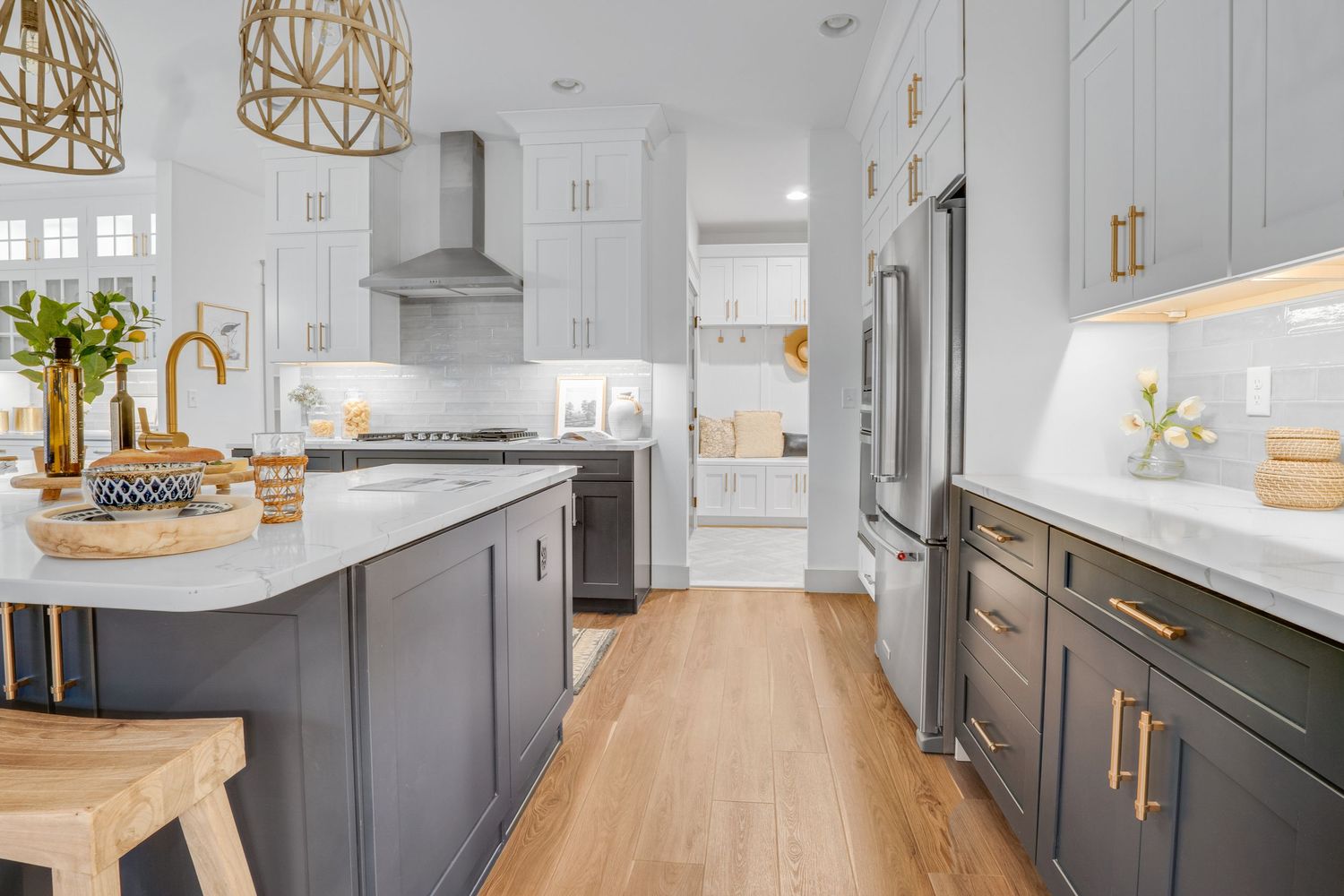 Modern kitchen with oversized island, custom cabinetry, stainless steel appliances, and hardwood flooring, photographed for residential real