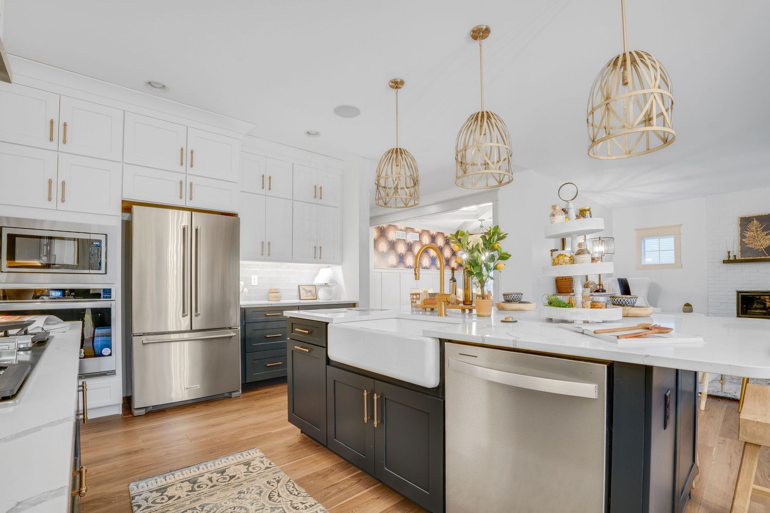Bright modern kitchen with large island, stainless steel appliances, white cabinetry, and pendant lighting, photographed for residential rea