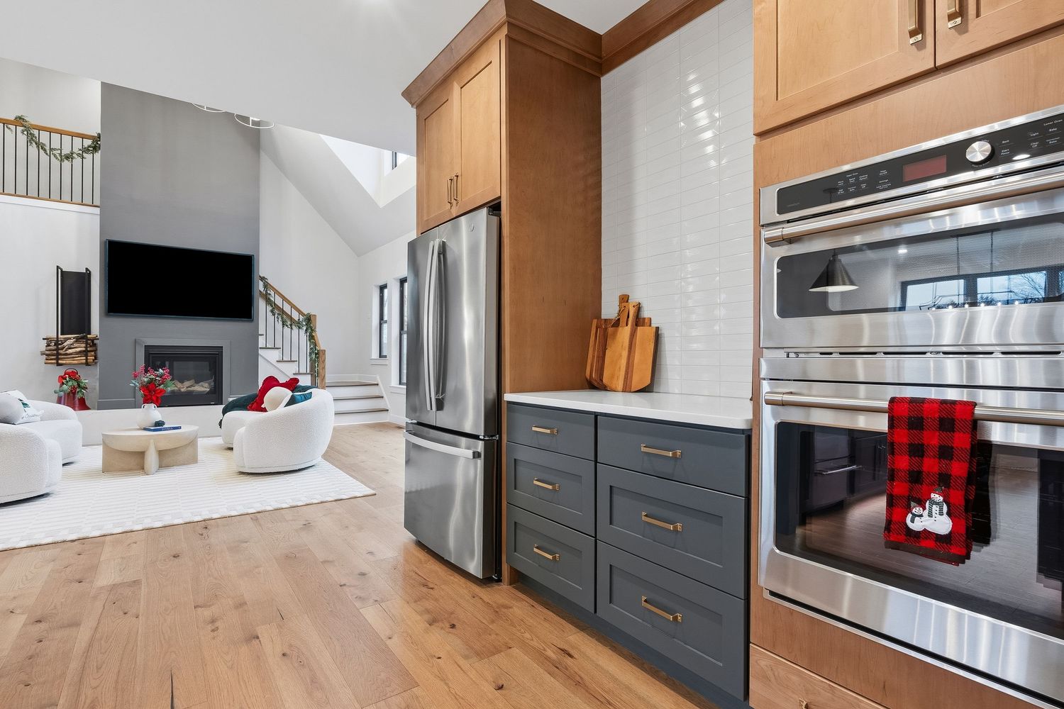 Kitchen with built-in appliances, custom cabinetry, and open view into living area, photographed for real estate marketing