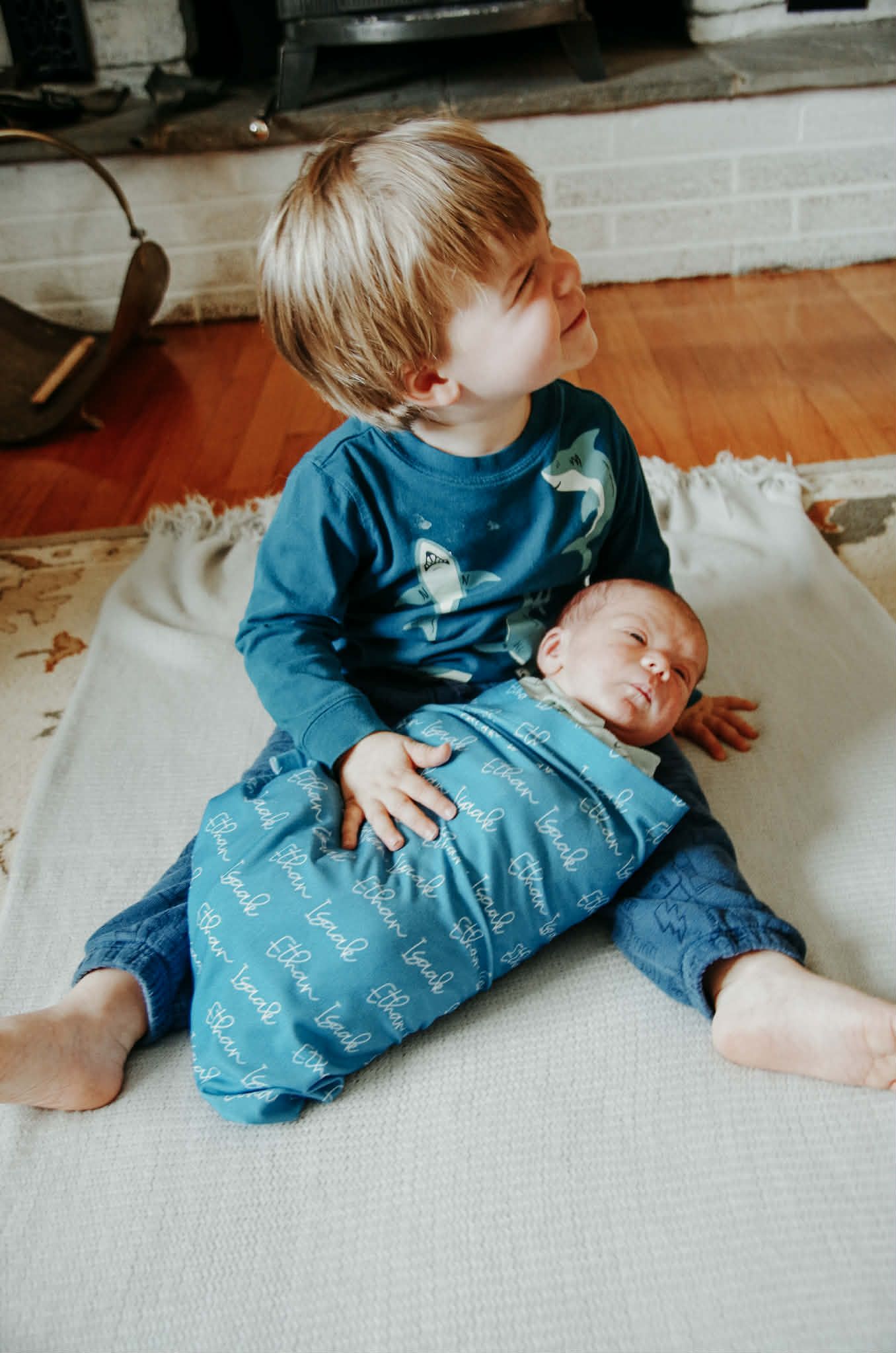 Newborn baby photo session with baby in swaddle with big brother in Baltimore, MD