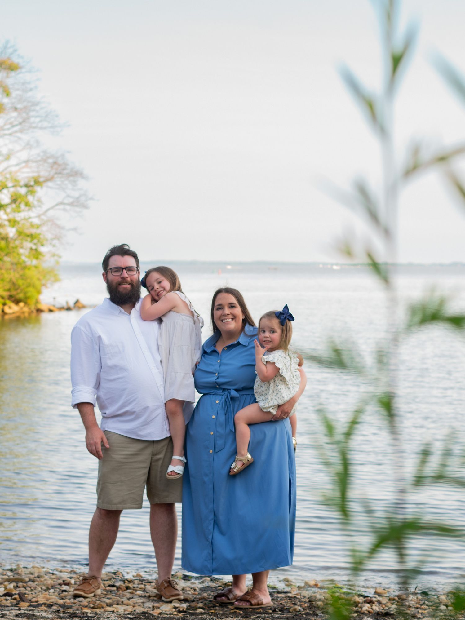 Family of four by the Chesapeake Bay during a family photo session in Havre de Grace, MD