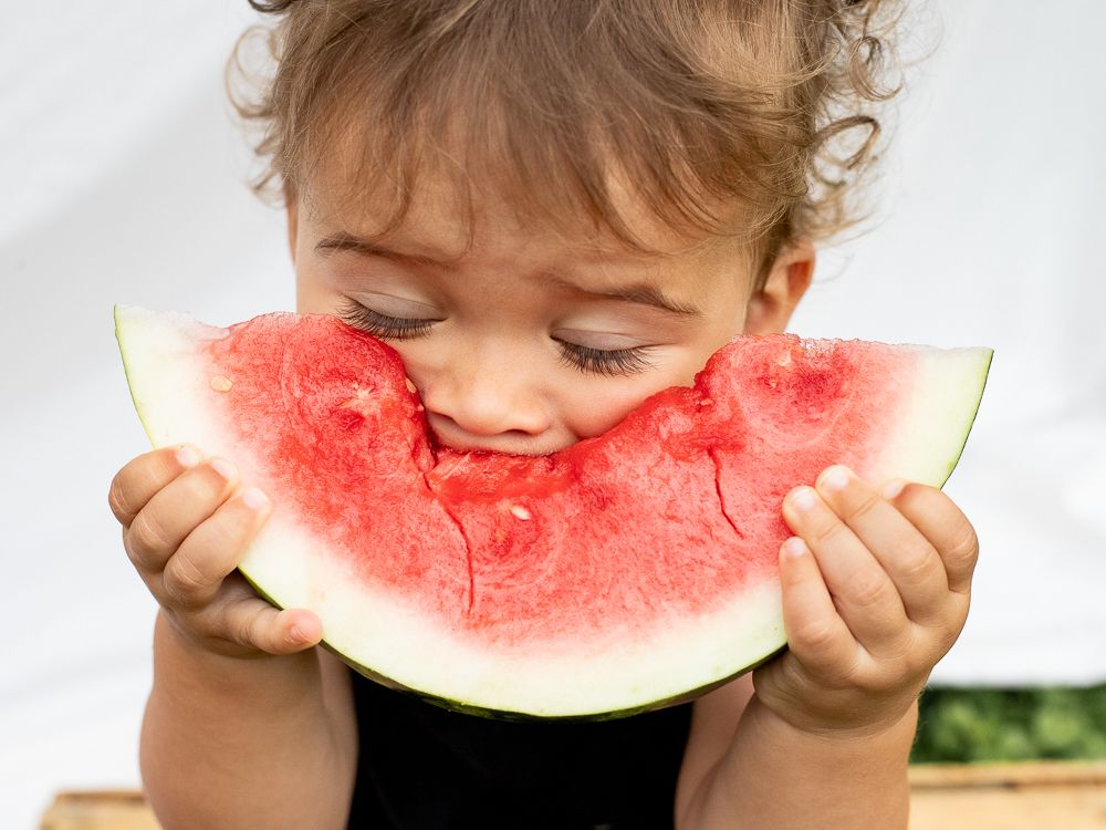 Young boy eating a watermelon in Baltimore, MD