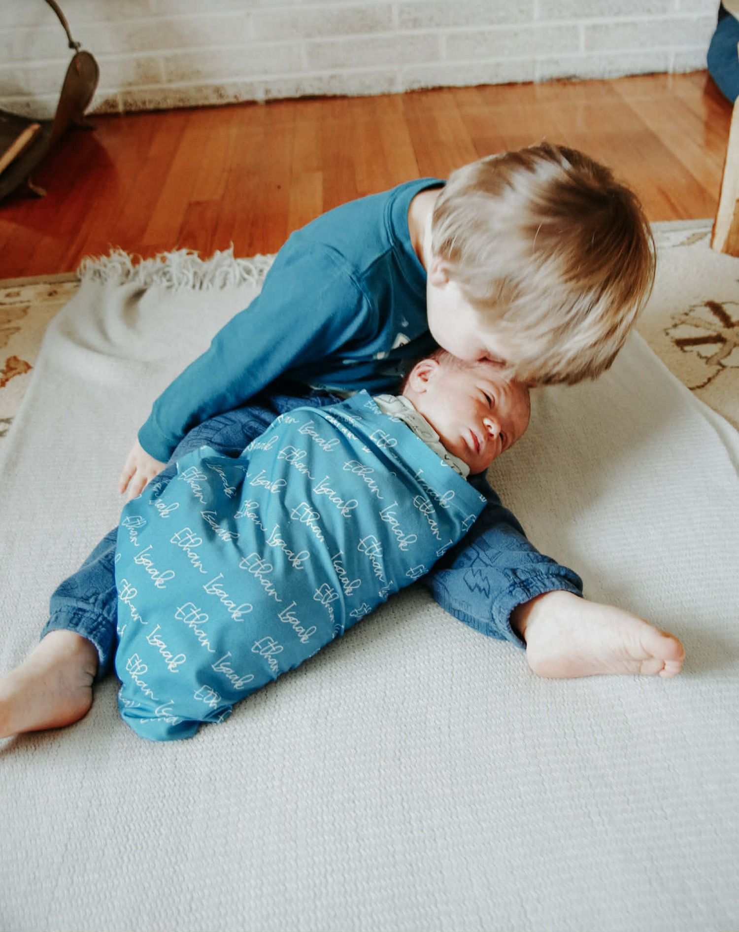 Newborn baby photo session with baby in swaddle with big brother in Baltimore, MD