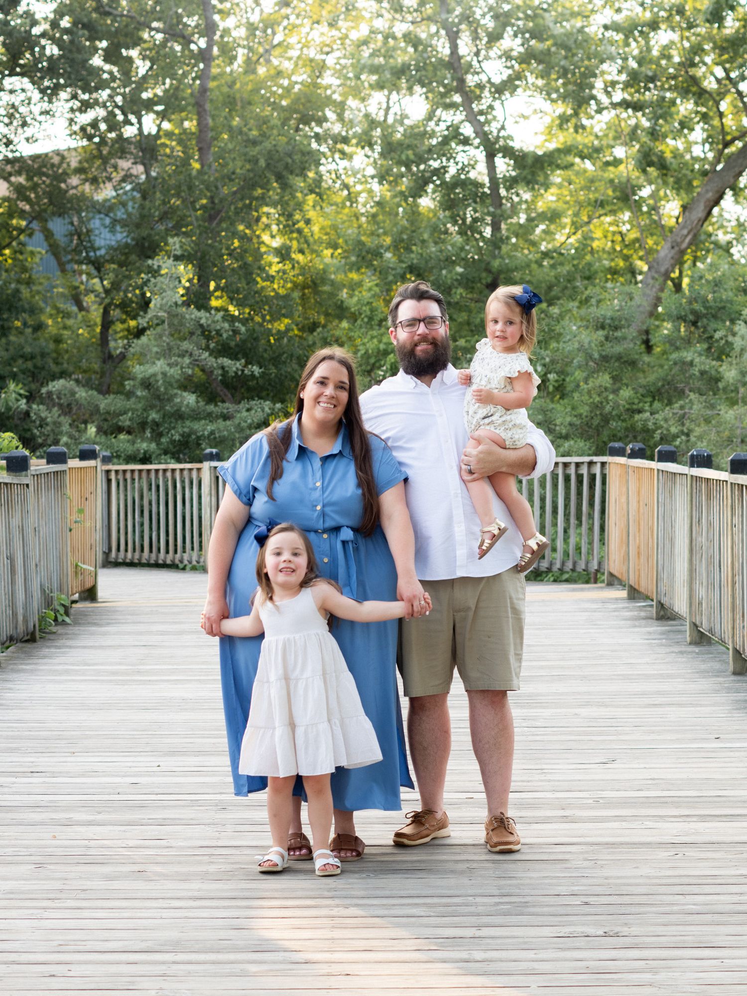 Family of four standing on a boardwalk during a family photo session in Havre de Grace, MD