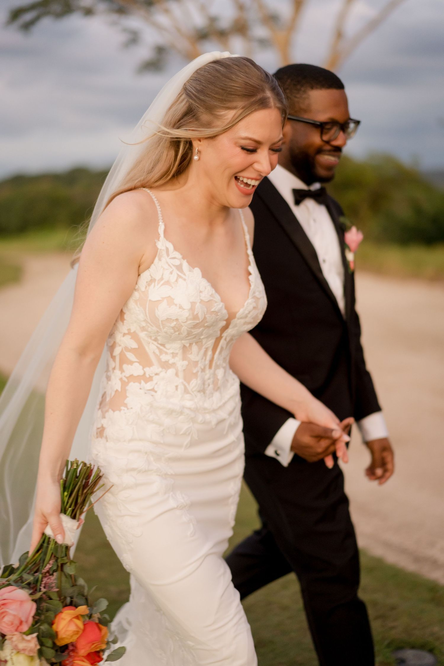 Candid wedding portrait capturing genuine laughter as the couple strolls together after their ceremony in Playa Conchal, Costa Rica.