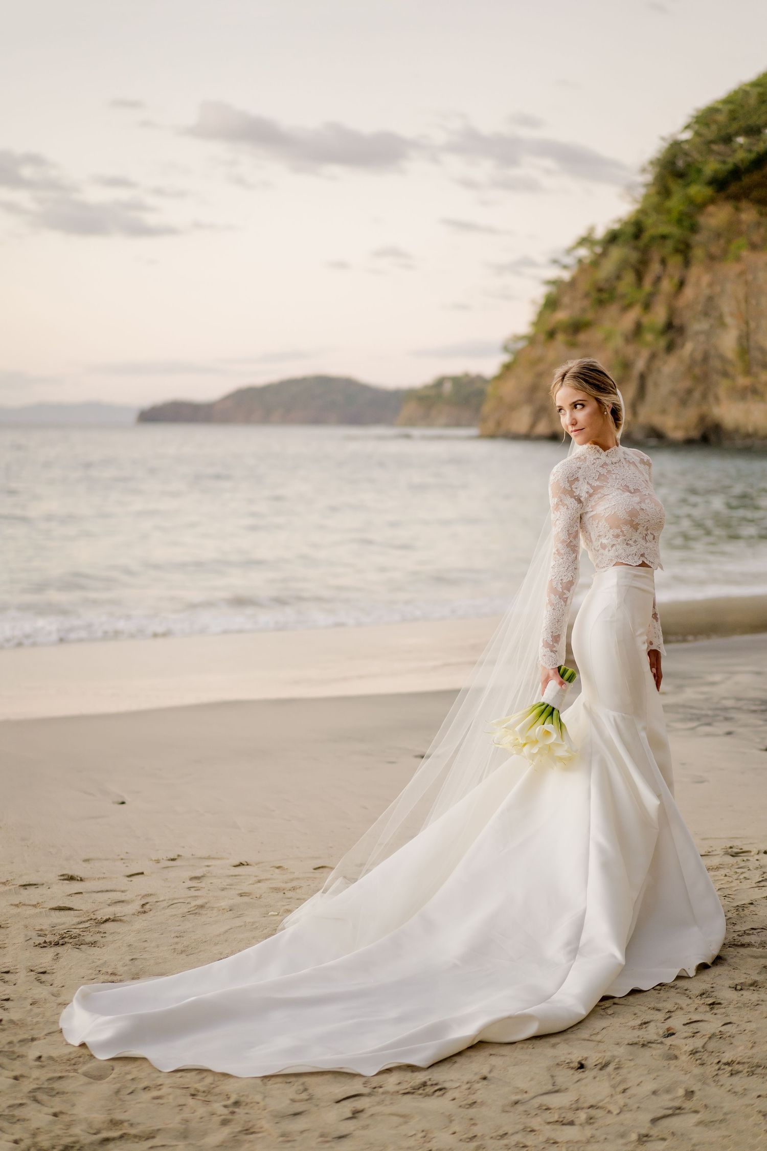 Timeless bridal portrait overlooking Papagayo, Costa Rica's coastline, featuring a flowing cathedral veil and minimalist wedding gown.