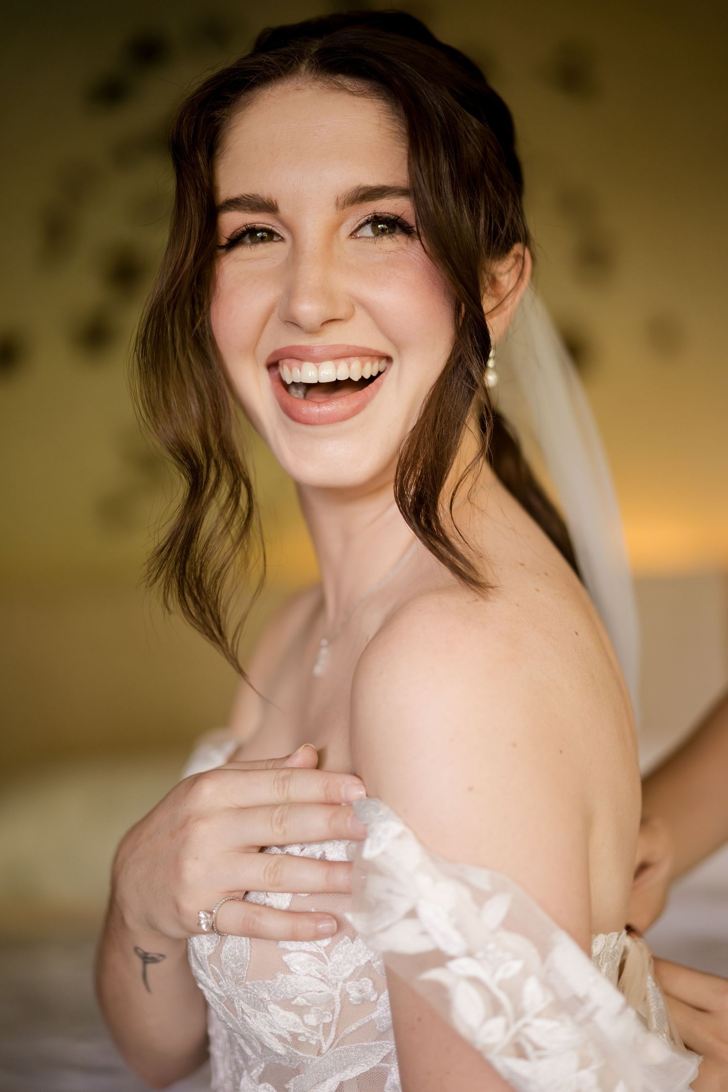 Joyful bridal portrait capturing authentic laughter and natural beauty in soft window light in a wedding in Guanacaste, Costa Rica.