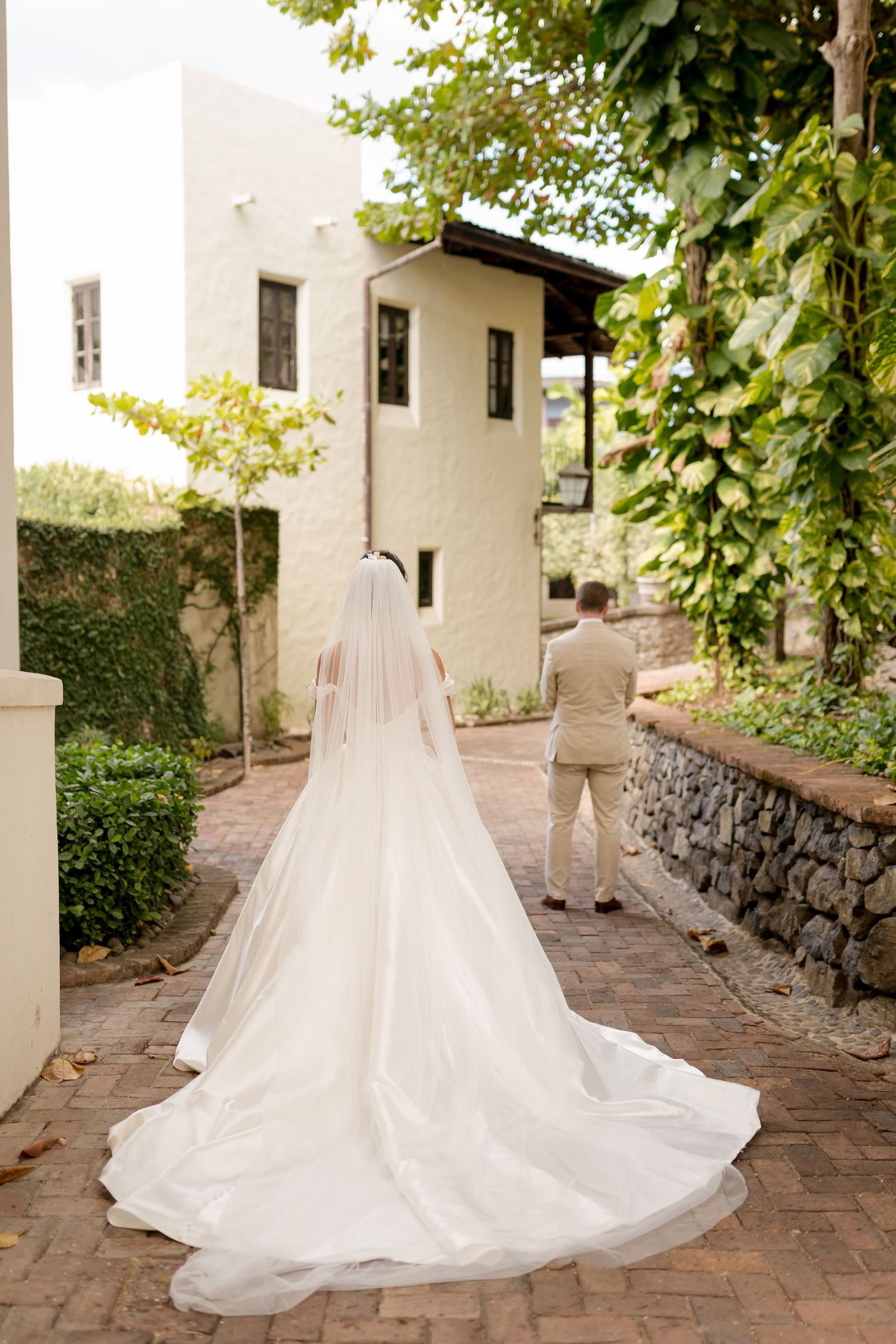 Flowing cathedral veil extending behind the bride as the couple walks toward their wedding ceremony Las Catalinas in Guanacaste, Costa Rica