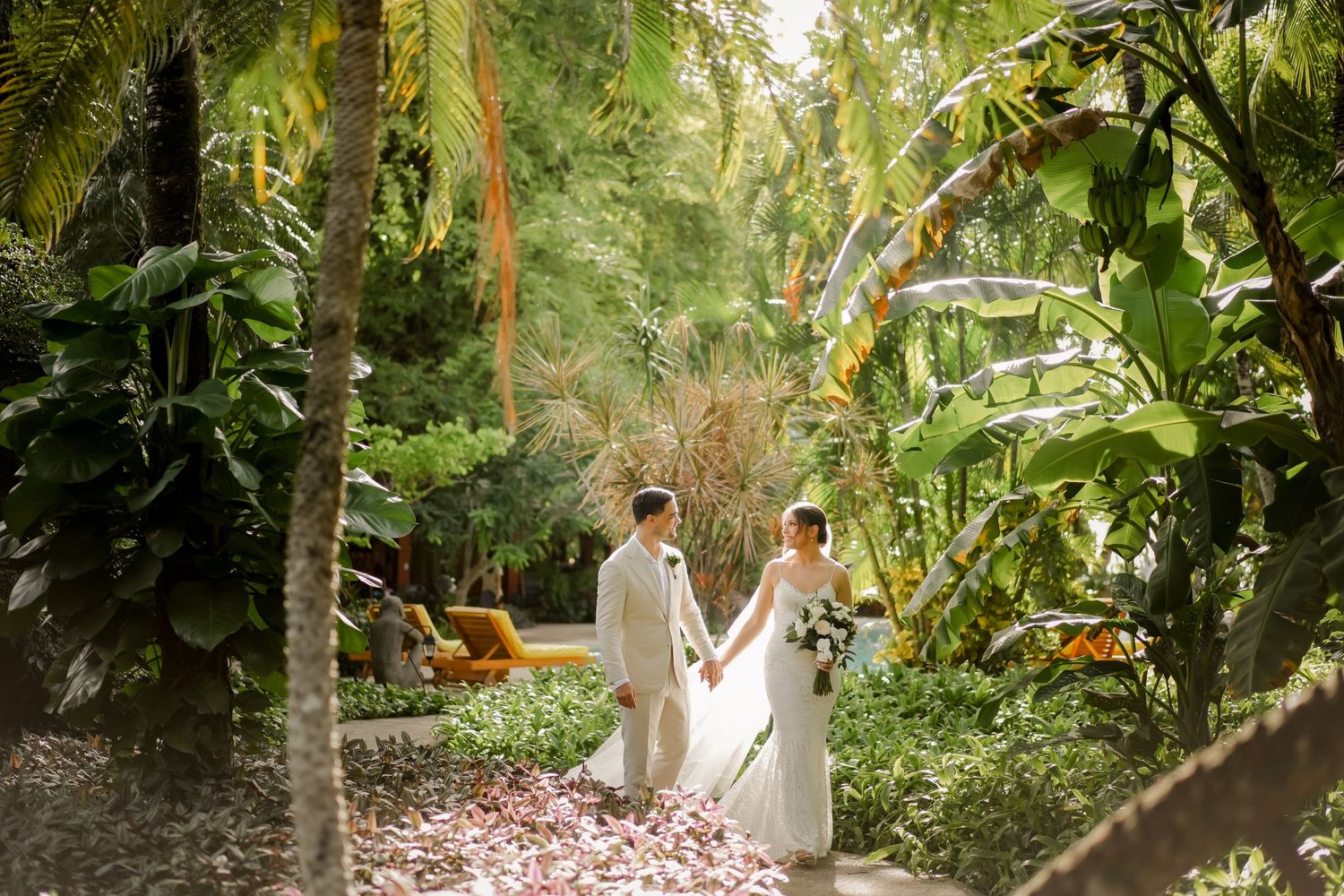 Luxury destination wedding portrait in a tropical garden in Tamarindo, Guanacaste, Costa Rica with lush rainforest scenery.