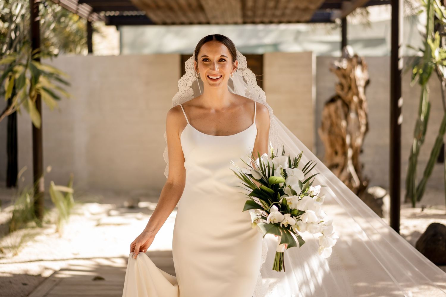 Bride making her entrance with bouquet and cathedral veil before the wedding ceremony at a luxury Costa Rica resort.