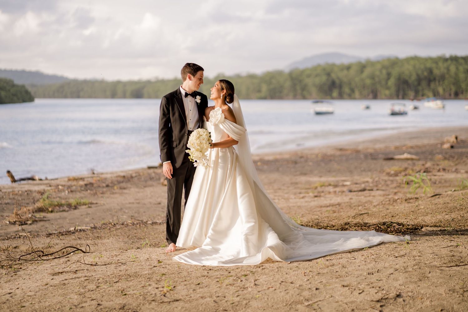 Bride and groom standing together along tranquil Pacific shoreline, showcasing an intimate coastal wedding portrait in Tamarindo Costa Rica