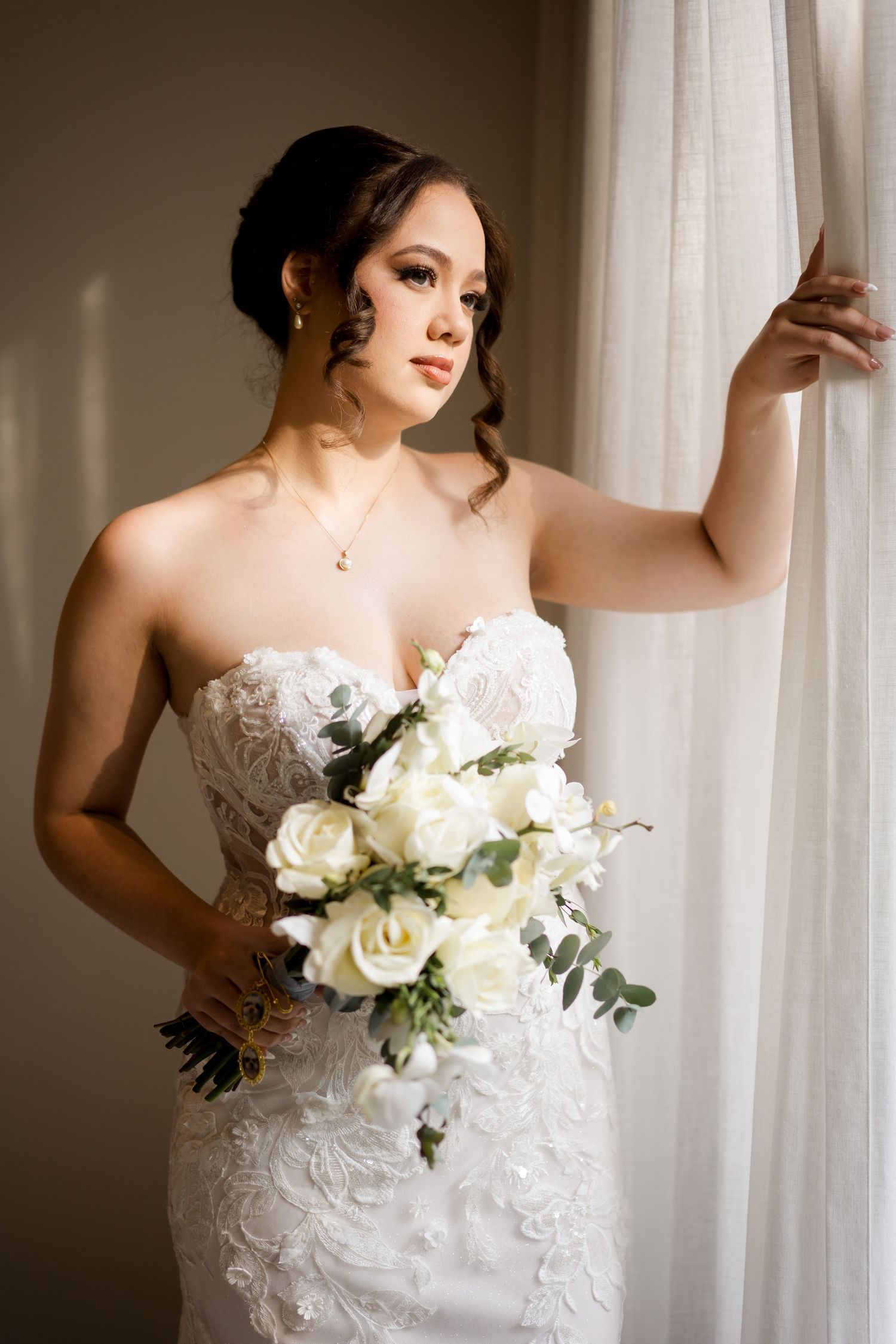 Elegant bridal portrait illuminated by natural window light, highlighting timeless wedding fashion and classic bridal styling.