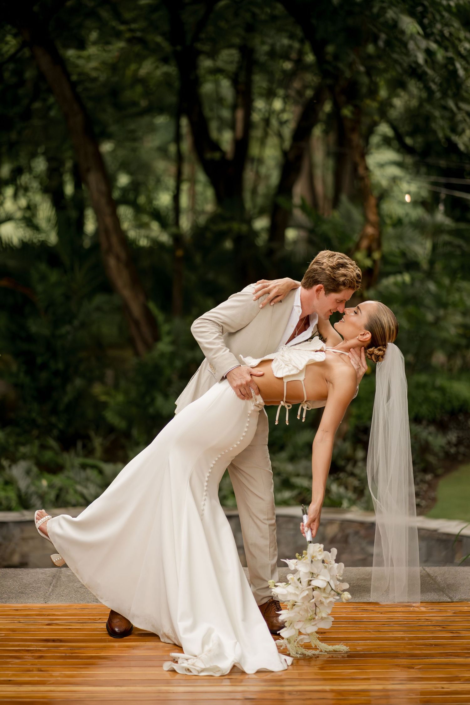 A graceful dip kiss captures the joy of newlyweds during romantic wedding portraits in Costa Rica.