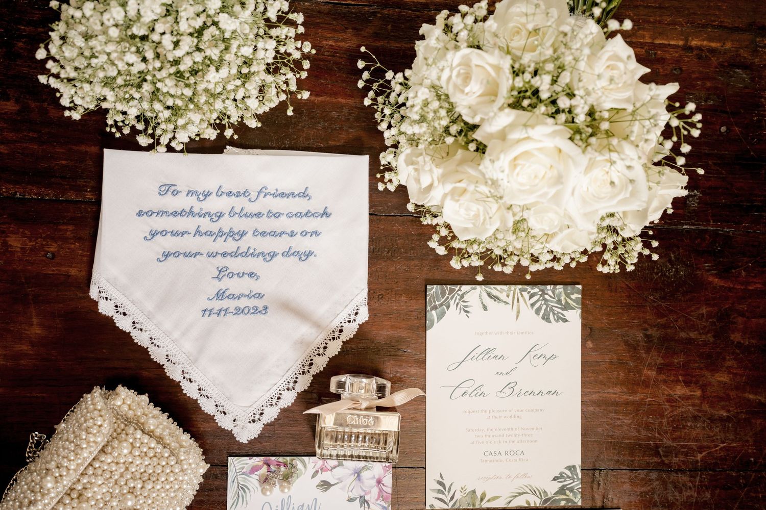 Editorial wedding flat lay with invitation suite, heirloom details, bridal perfume, and luxury wedding stationery.