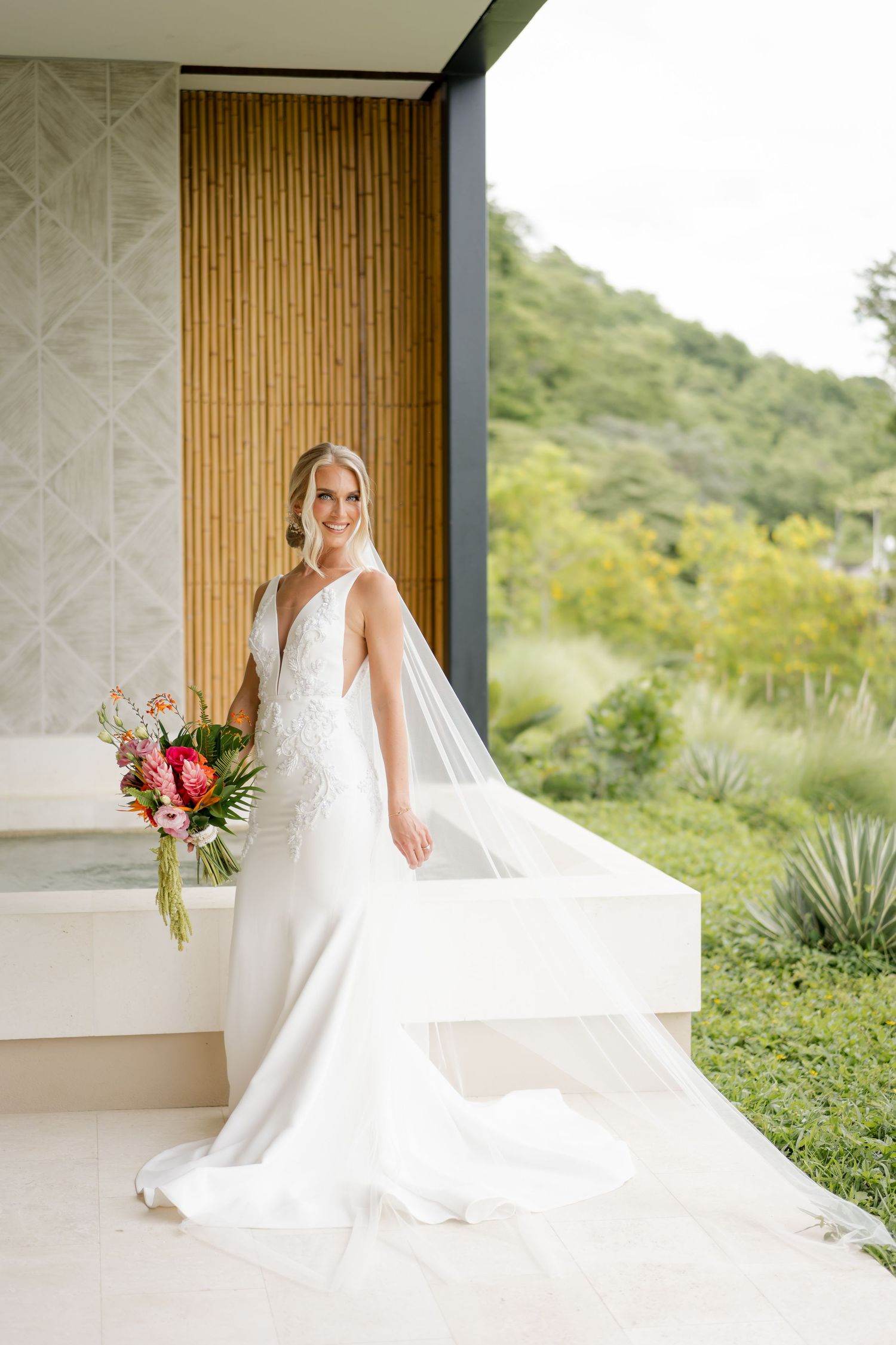 Contemporary bridal portrait featuring a flowing cathedral veil, minimalist wedding gown and tropical resort in Andaz Residences.