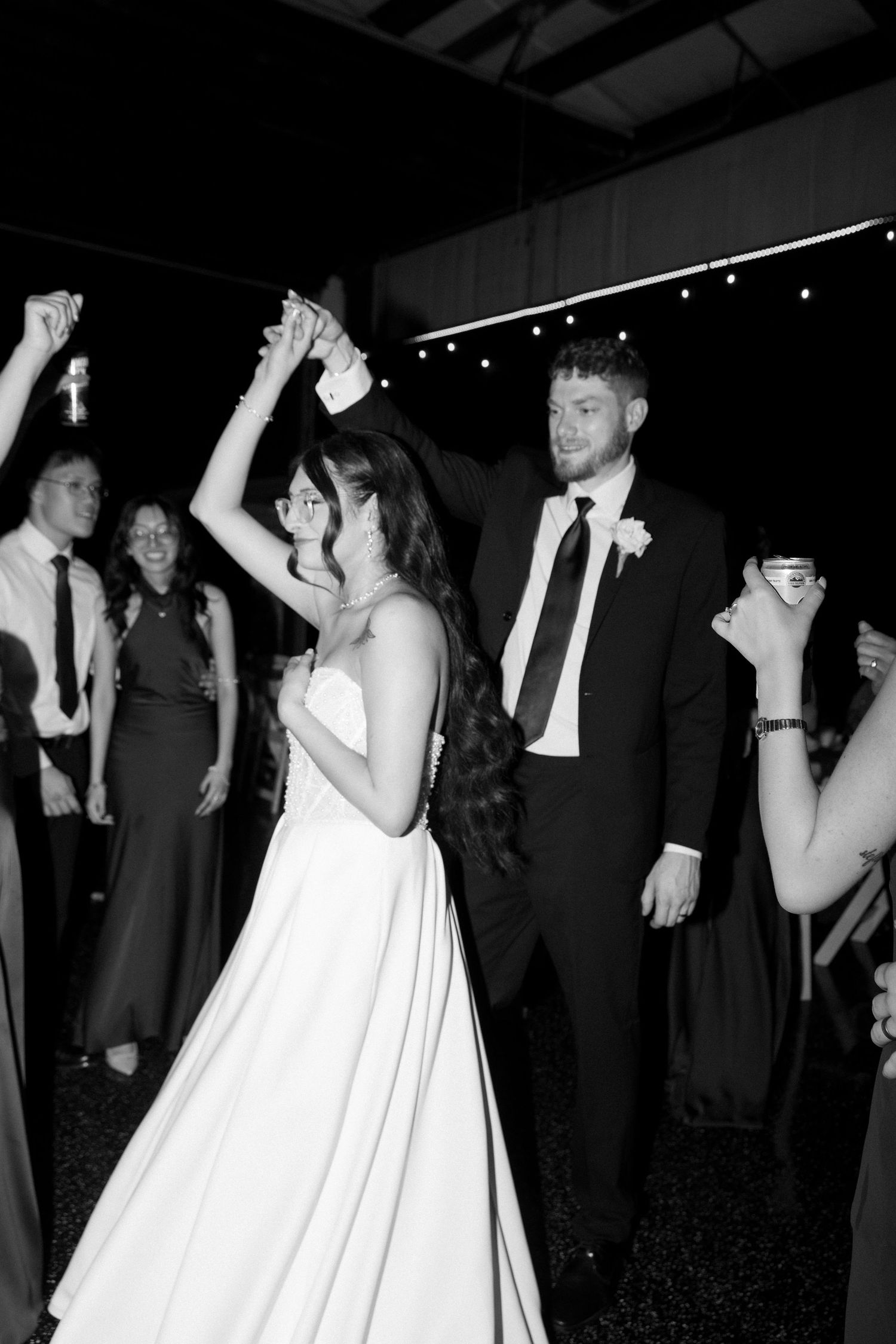 Bride and groom share a first dance surrounded by guests at their wedding reception.