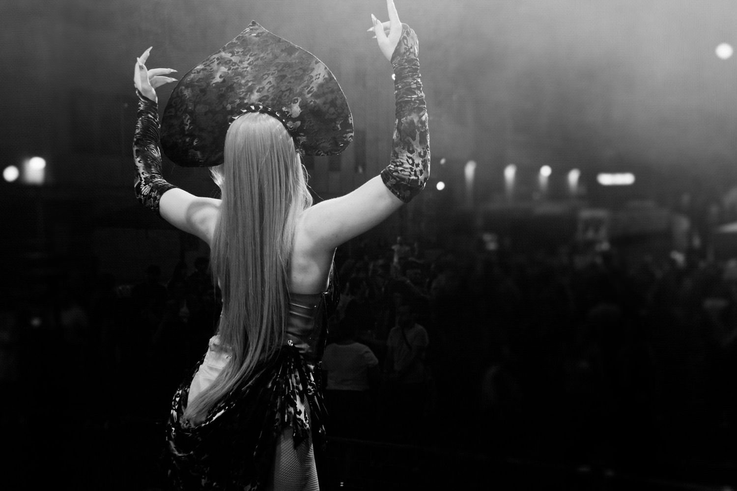 Black and white picture of a drag performer dancing in front of an audience.