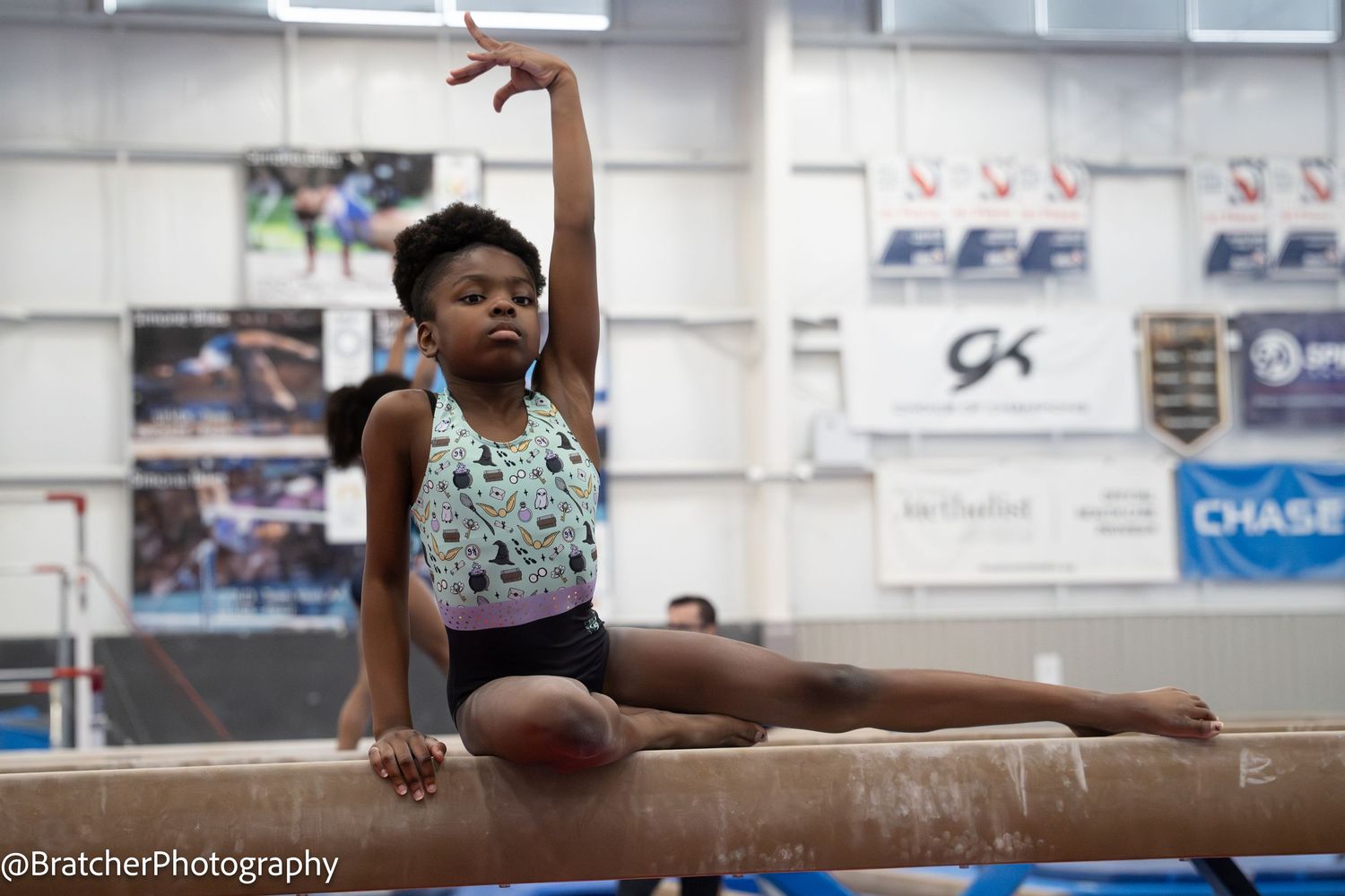 Young gymnast performs split on balance beam during gymnastics practice. bratcher photography and houston photographer