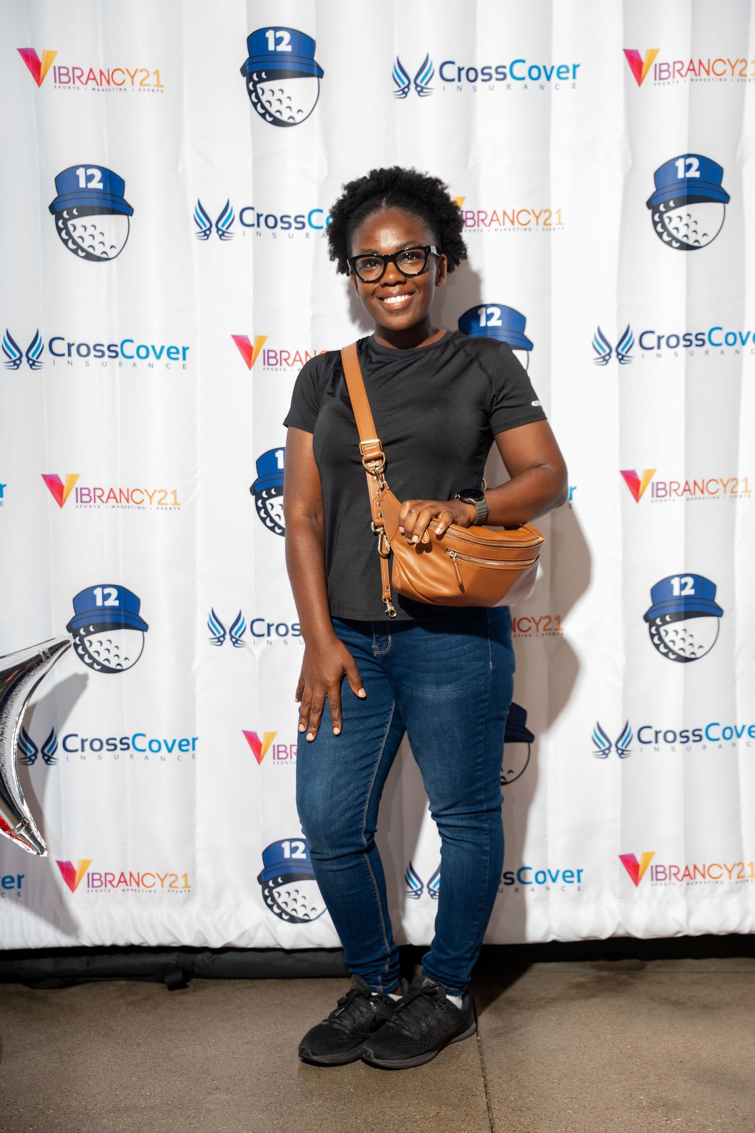 Woman posing in front of CrossCover and Vibrancy21 event step-and-repeat banner. bratcher photography and houston photographer