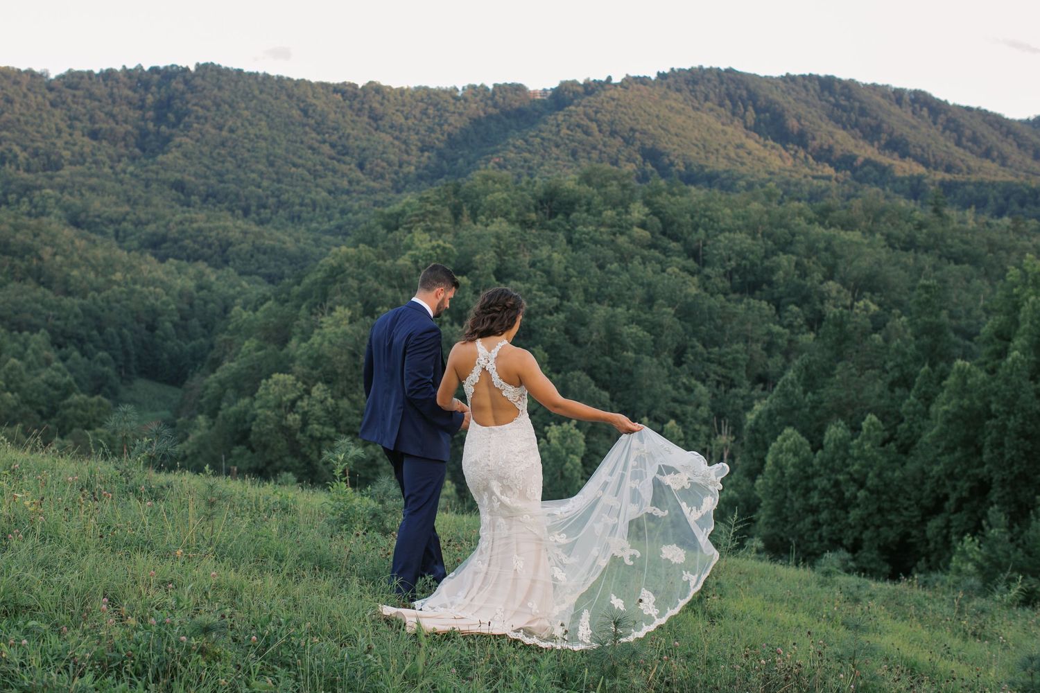 Bride and Groom walking towards mountain views at Mountain Mist Farms wedding in Pigeon Forge, Tennessee