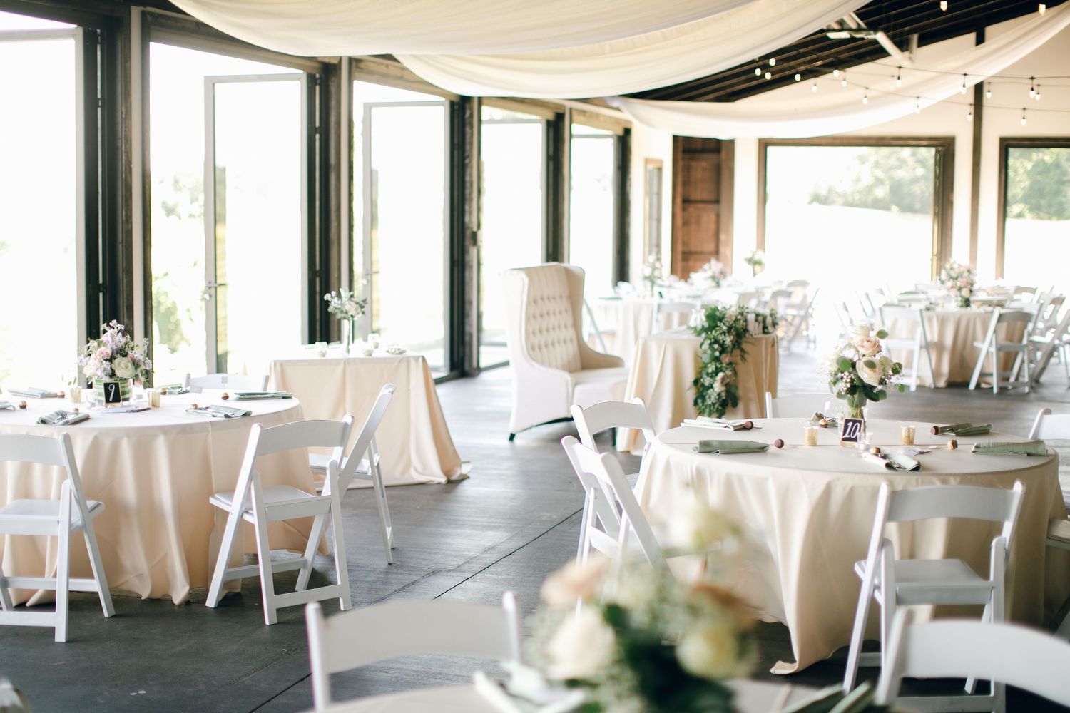 Wedding reception space decorated with creamy linens and florals at Chateau Selah wedding in Tennessee.