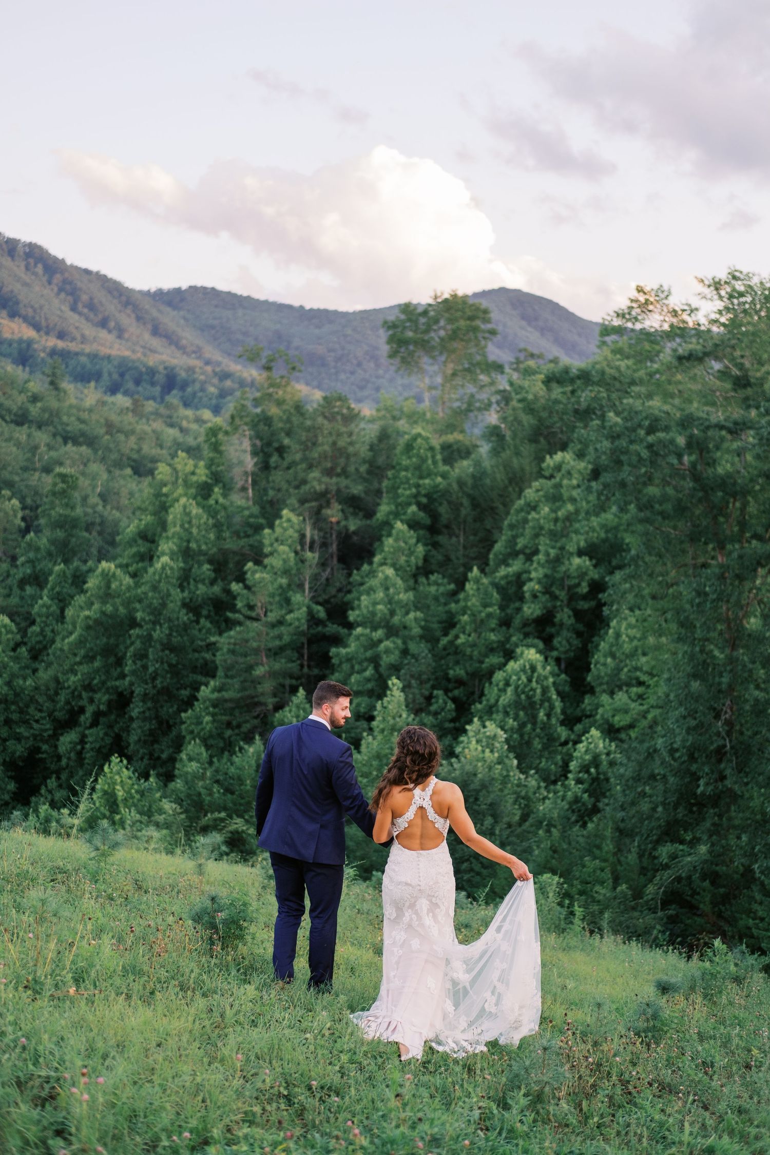 Bride and Groom walking towards mountain views at Mountain Mist Farms wedding in Pigeon Forge, Tennessee