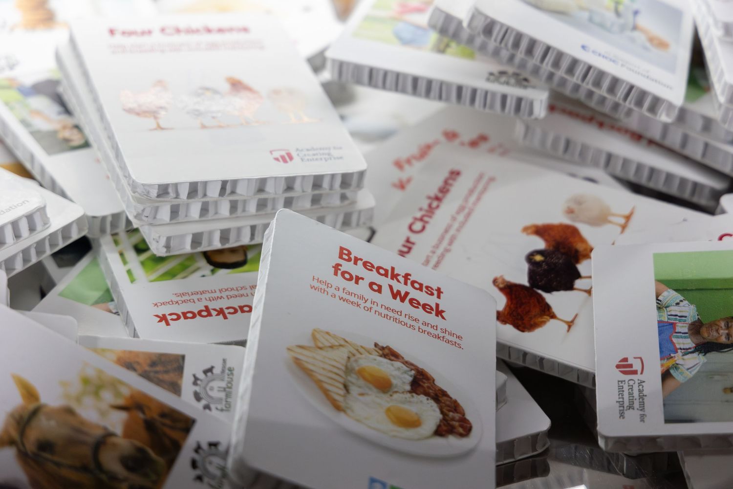 Stack of colorful recipe booklets including Breakfast for a Week and Four Chickens.