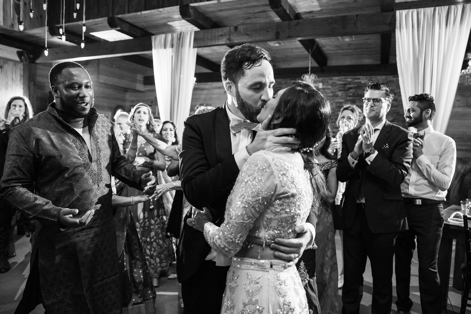 Black and white candid reception moment with guests watching a dance.