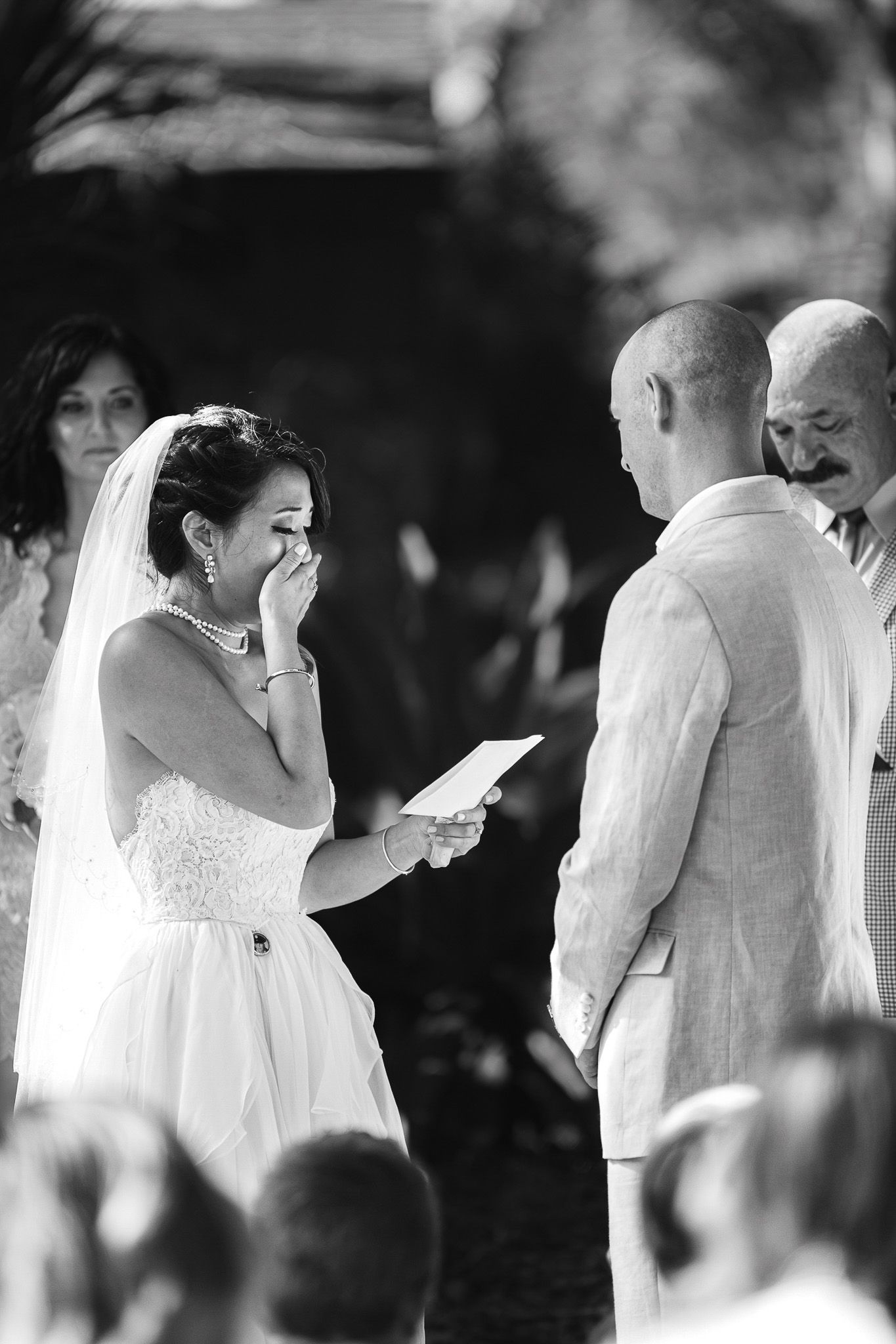 An emotional moment during wedding vows ceremony captured in black and white.
