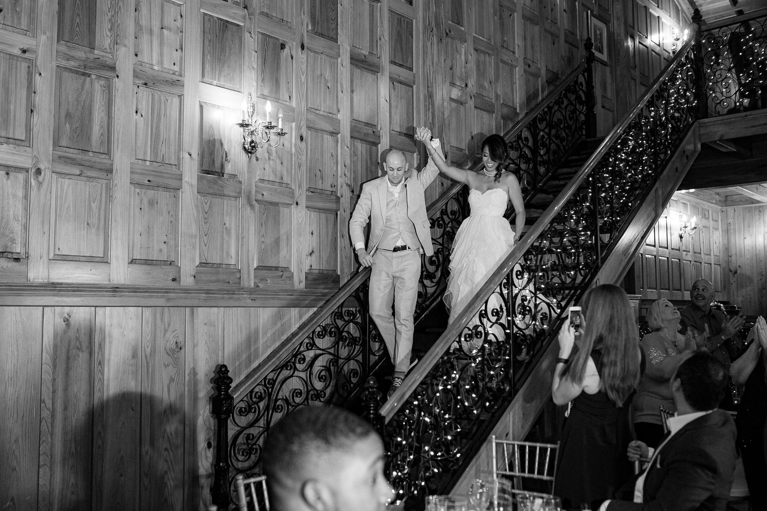 Black and white photo of elegant staircase descent at formal event.