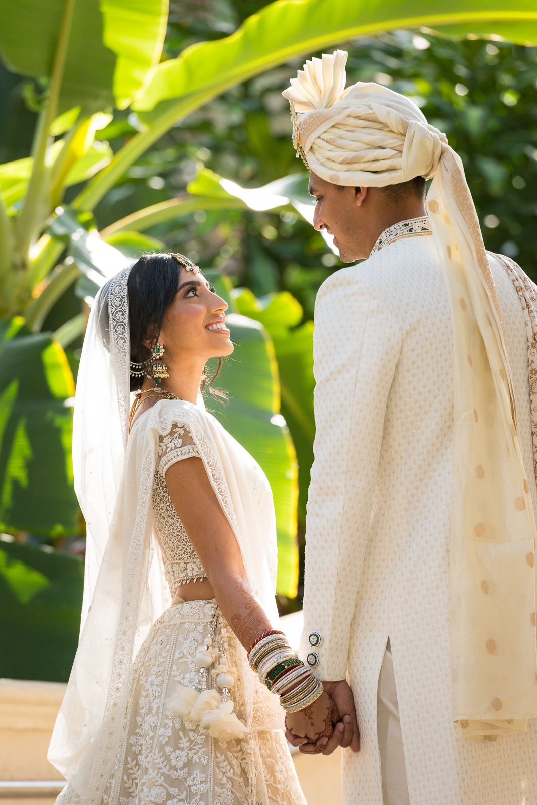 Tropical garden wedding scene with traditional white attire and cultural details.