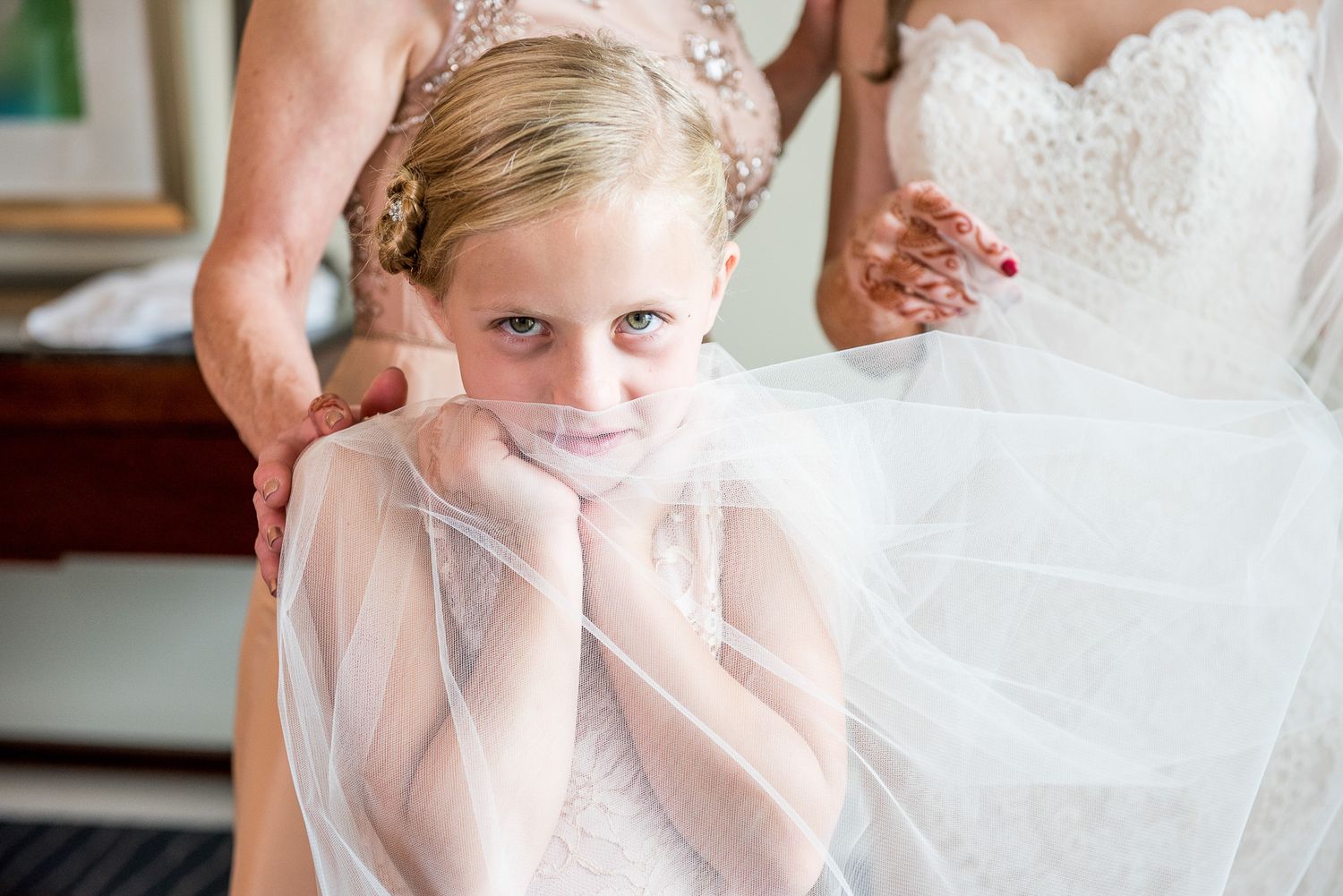 Young attendant in white dress during wedding preparations.