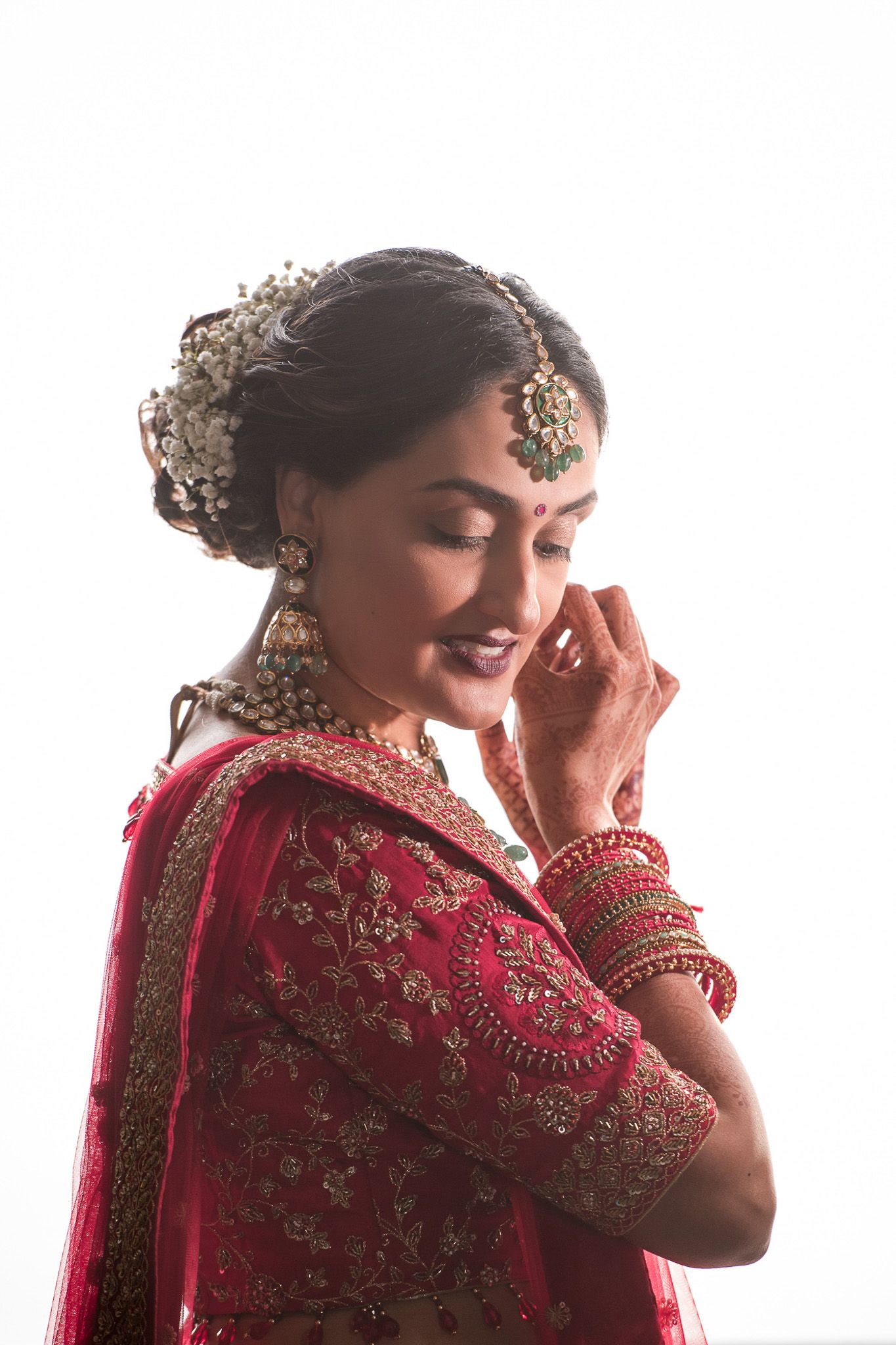 Bridal portrait showing intricate gold headpiece and traditional South Asian wedding attire in soft lighting.