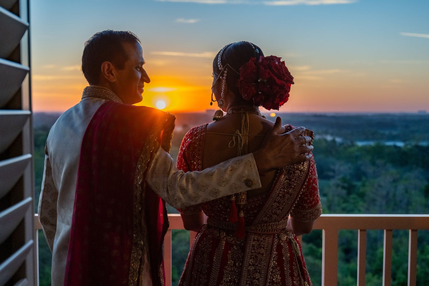 Romantic silhouette of couple enjoying sunset view from balcony.