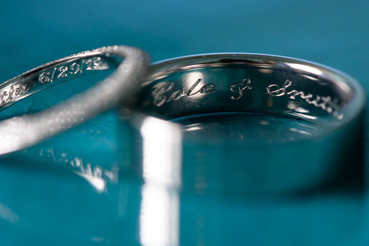Close-up macro shot of wedding rings with engraved text inside.