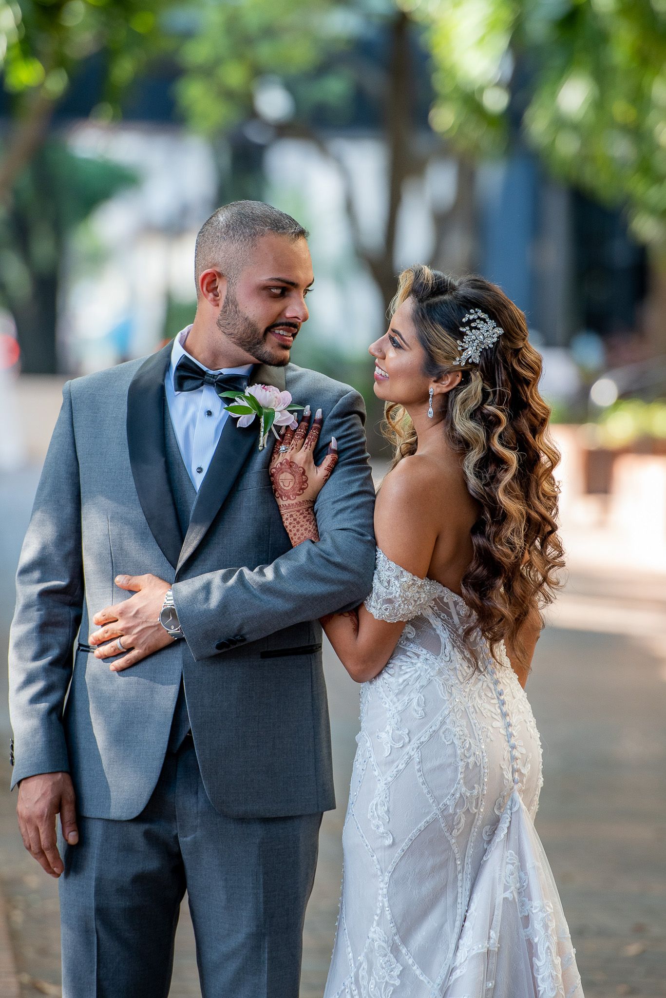 Romantic outdoor portrait of newlyweds in formal attire sharing intimate moment.