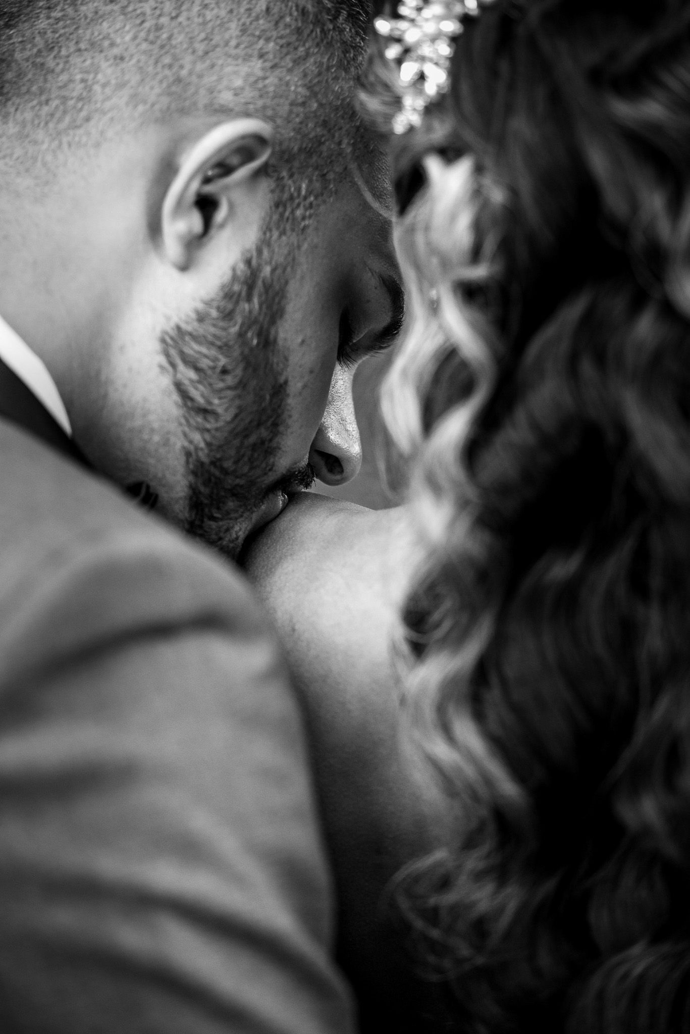 Intimate black and white close-up of tender wedding moment.