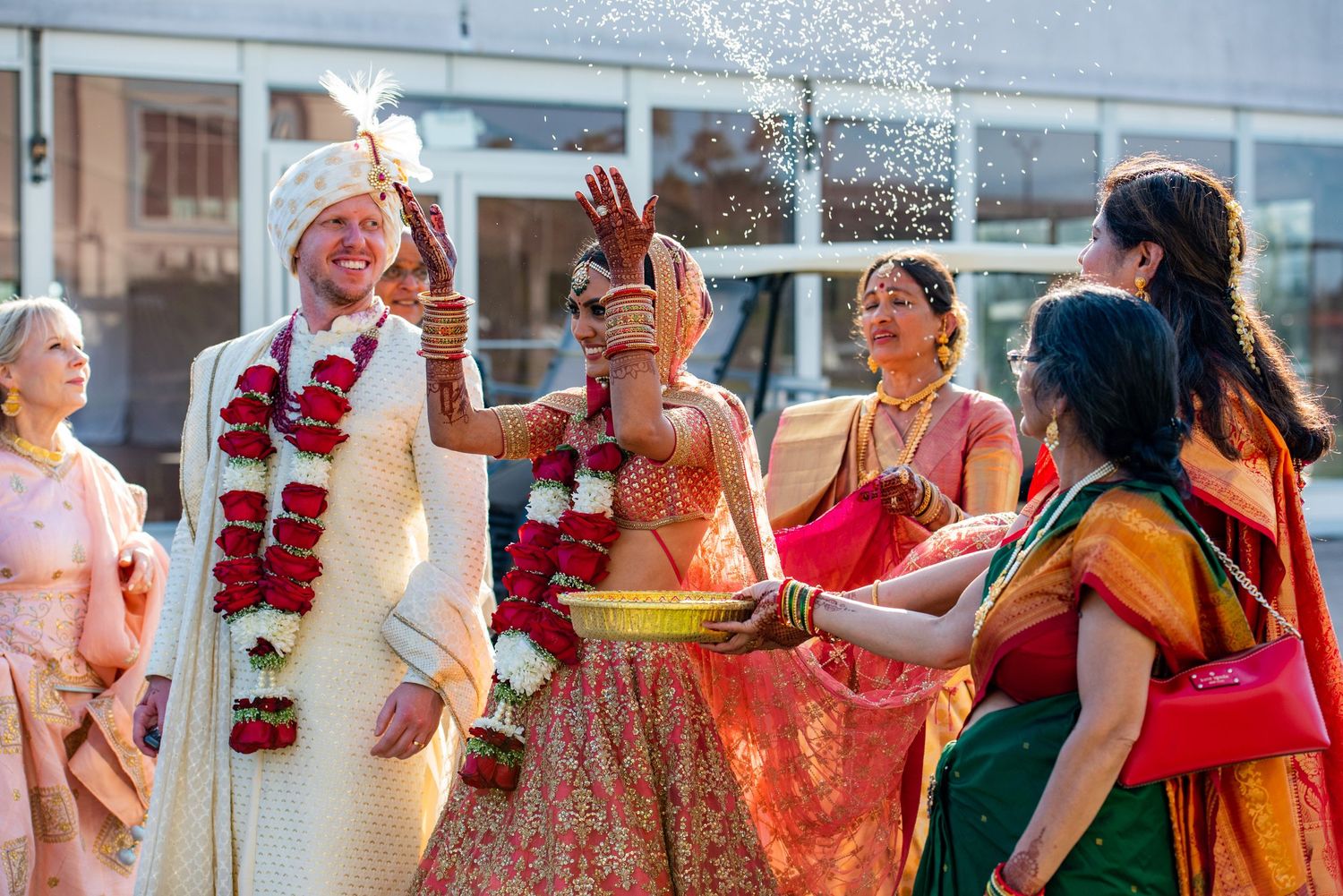 Traditional wedding celebration with guests throwing rice and performing ceremonial rituals.