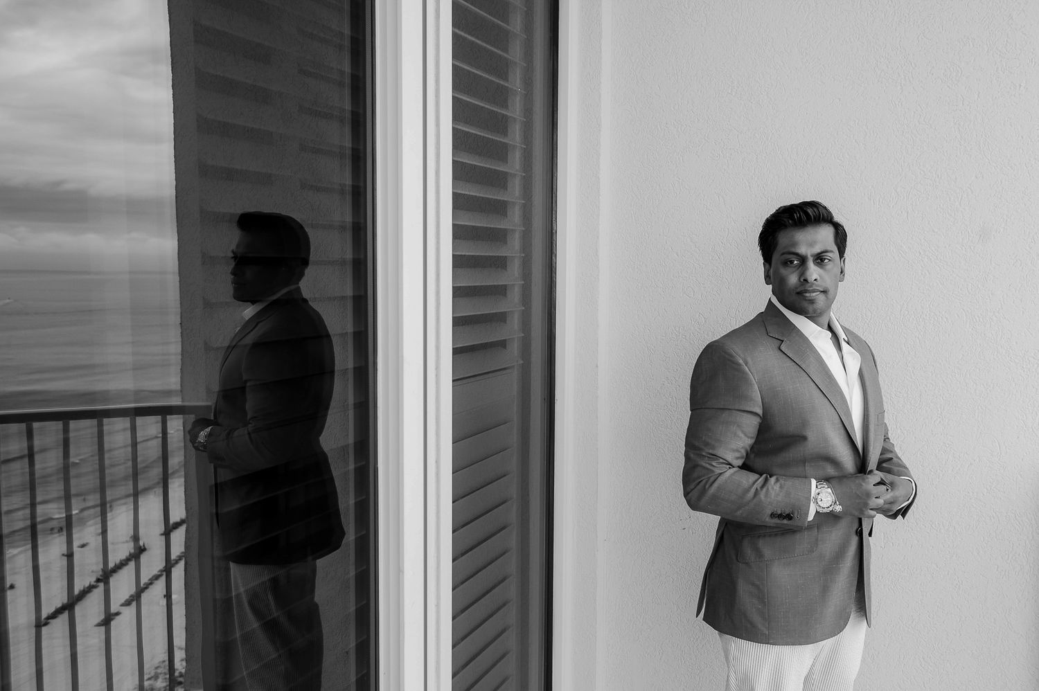 Elegant black and white portrait on a balcony with ocean view.