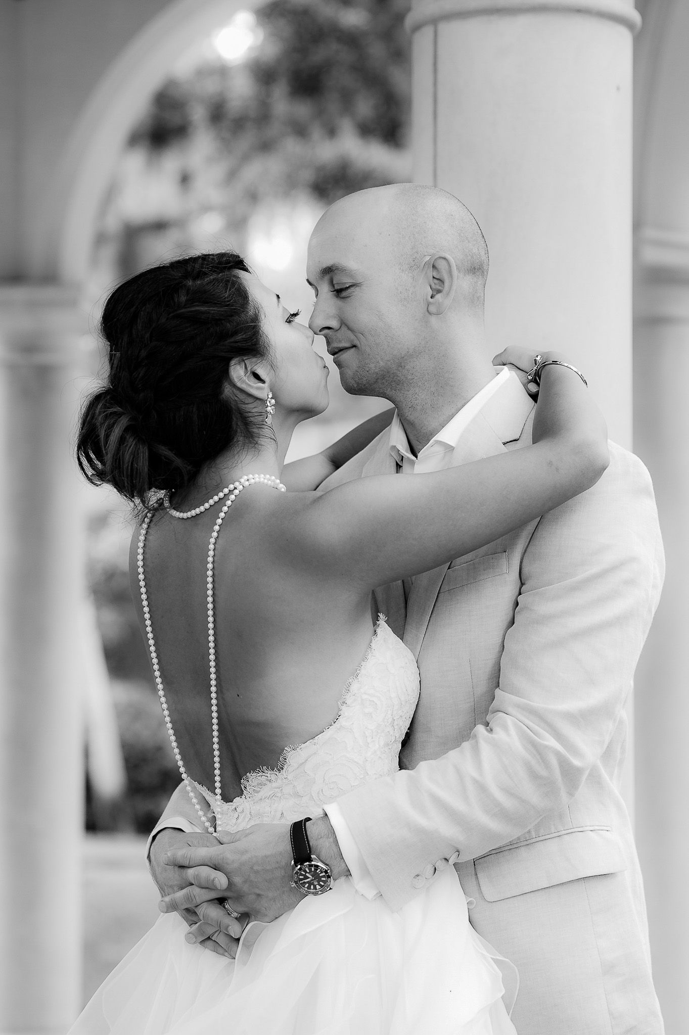 Black and white intimate moment of newlyweds dancing in elegant setting.