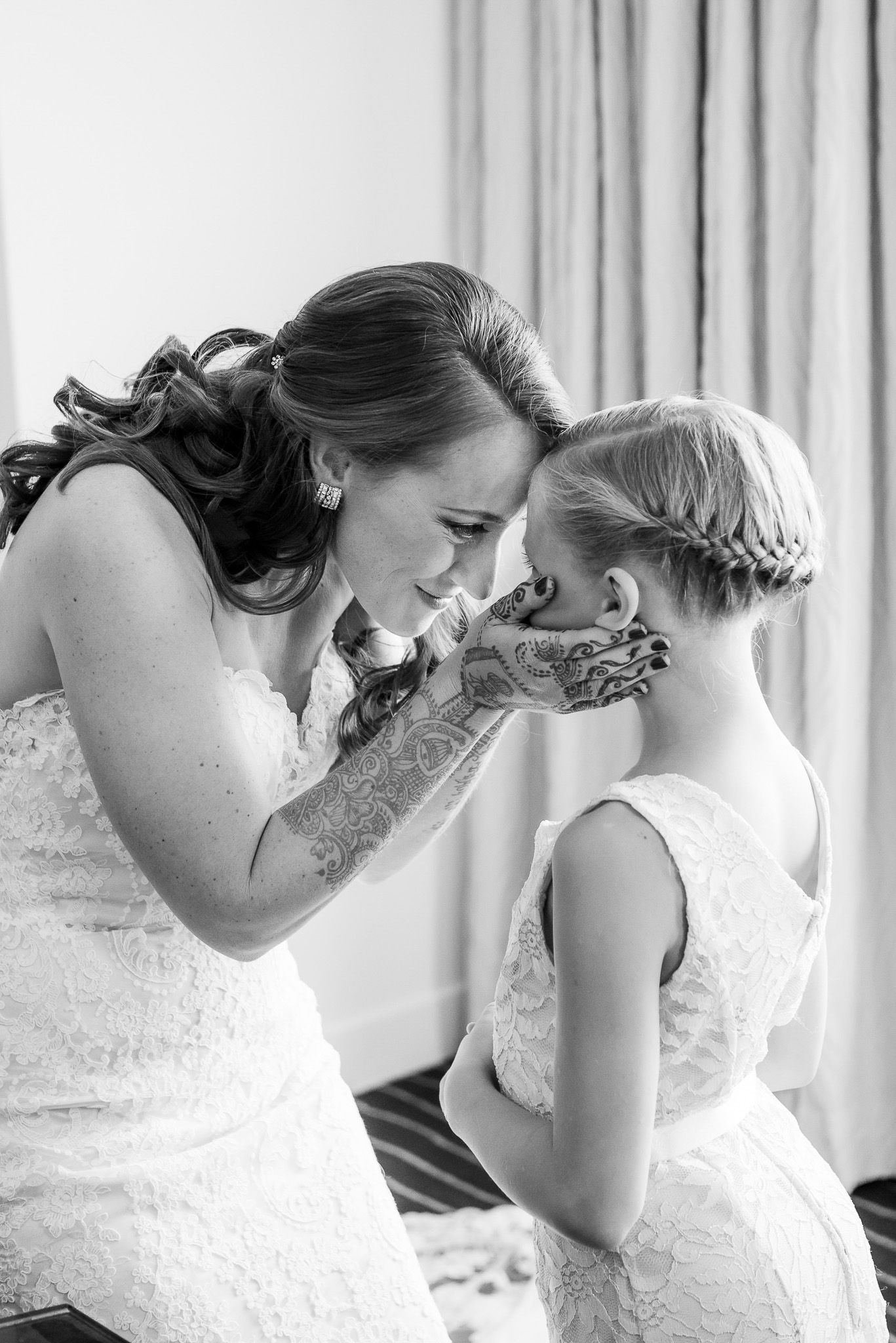 Black and white tender moment captured during wedding preparations.