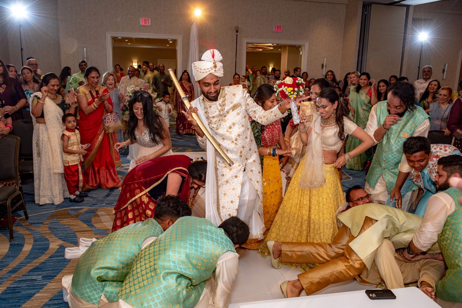 Wedding guests dancing energetically during traditional Indian celebration in formal attire.