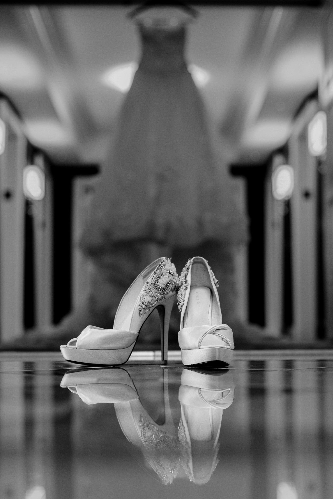 Wedding dress silhouette with elegant bridal shoes reflection on glossy floor.